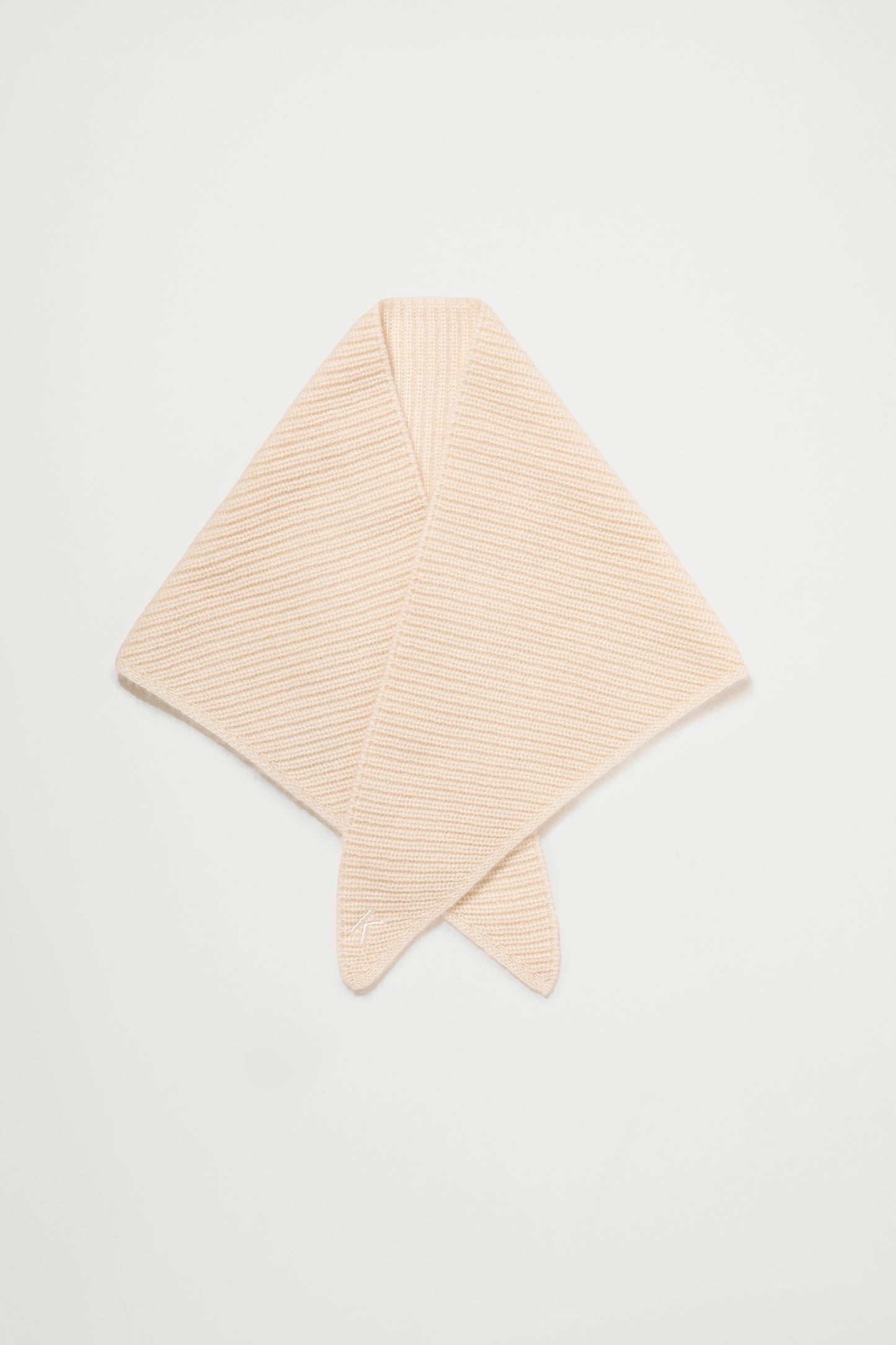 Knitted Cashmere Neck Tie in Cream folded flat in diamond shape, showing ribbed knit texture and pointed ends
