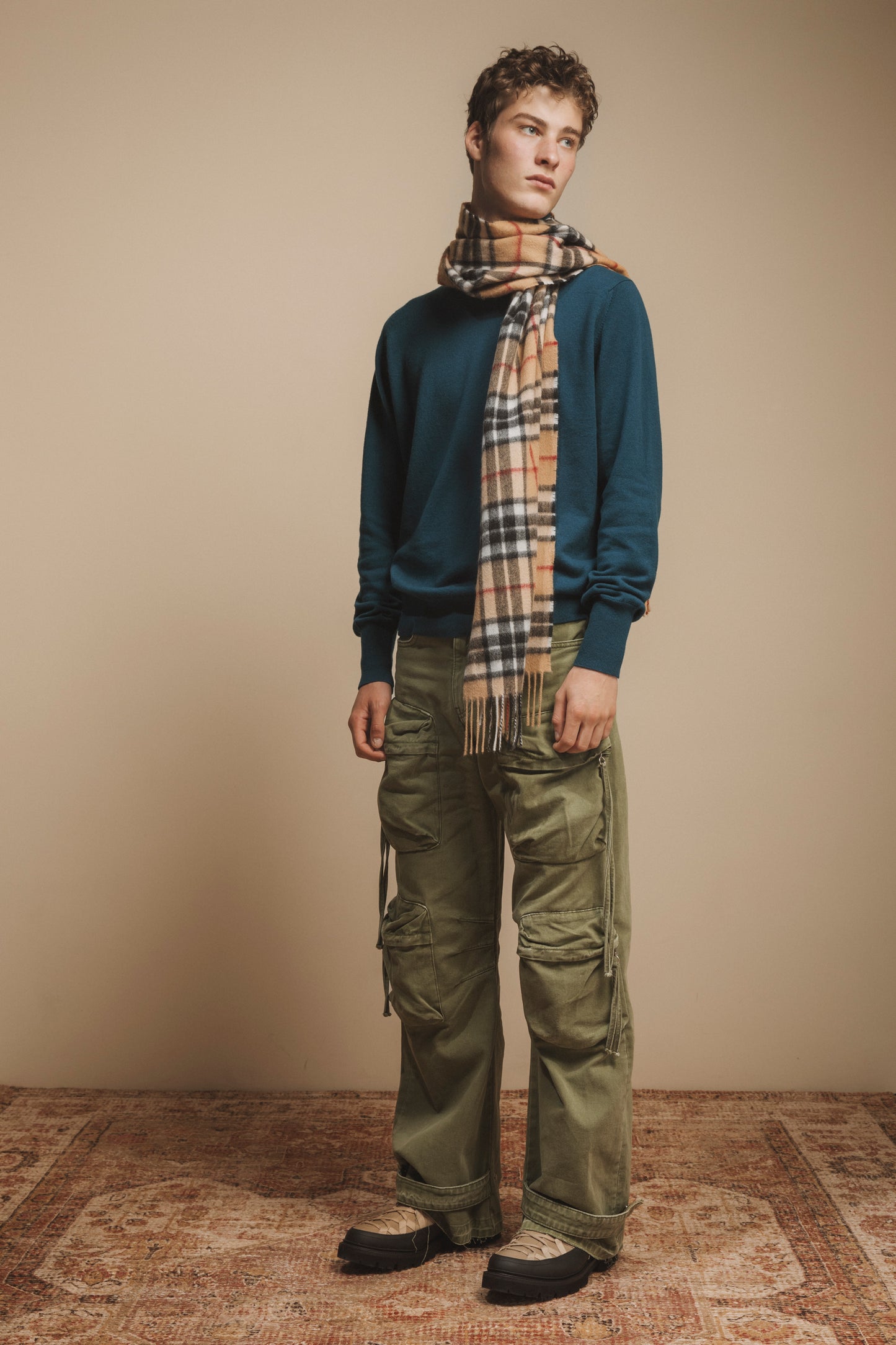Made in Scotland Scotty Thompson Cashmere Wide Scarf in Camel, classic plaid pattern with fringed ends, styled on model with teal sweater