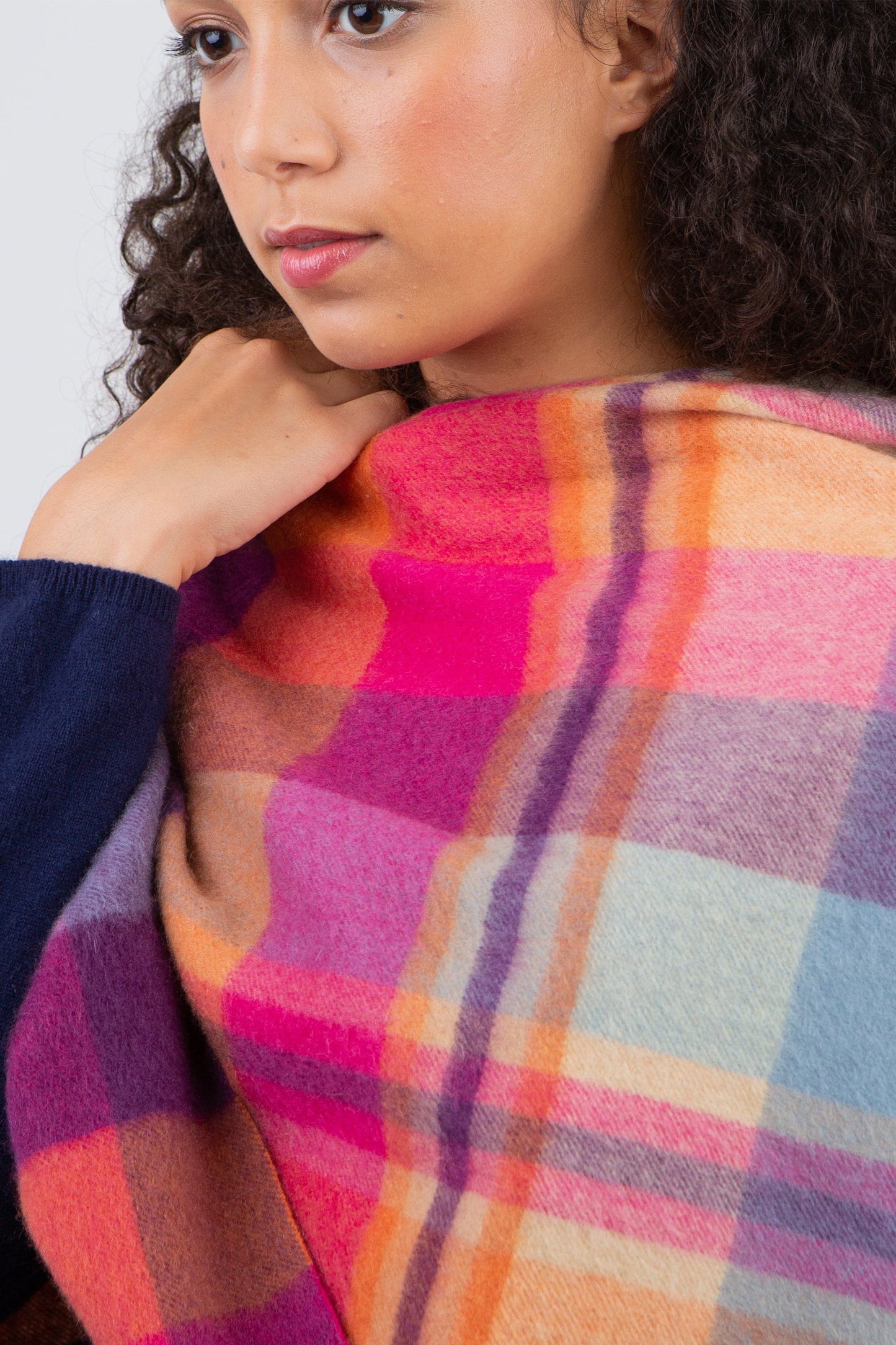 Close-up of Square Check Cashmere Wrap in Orient Ginger draped over shoulder, showing vibrant pink, orange, and purple plaid weave