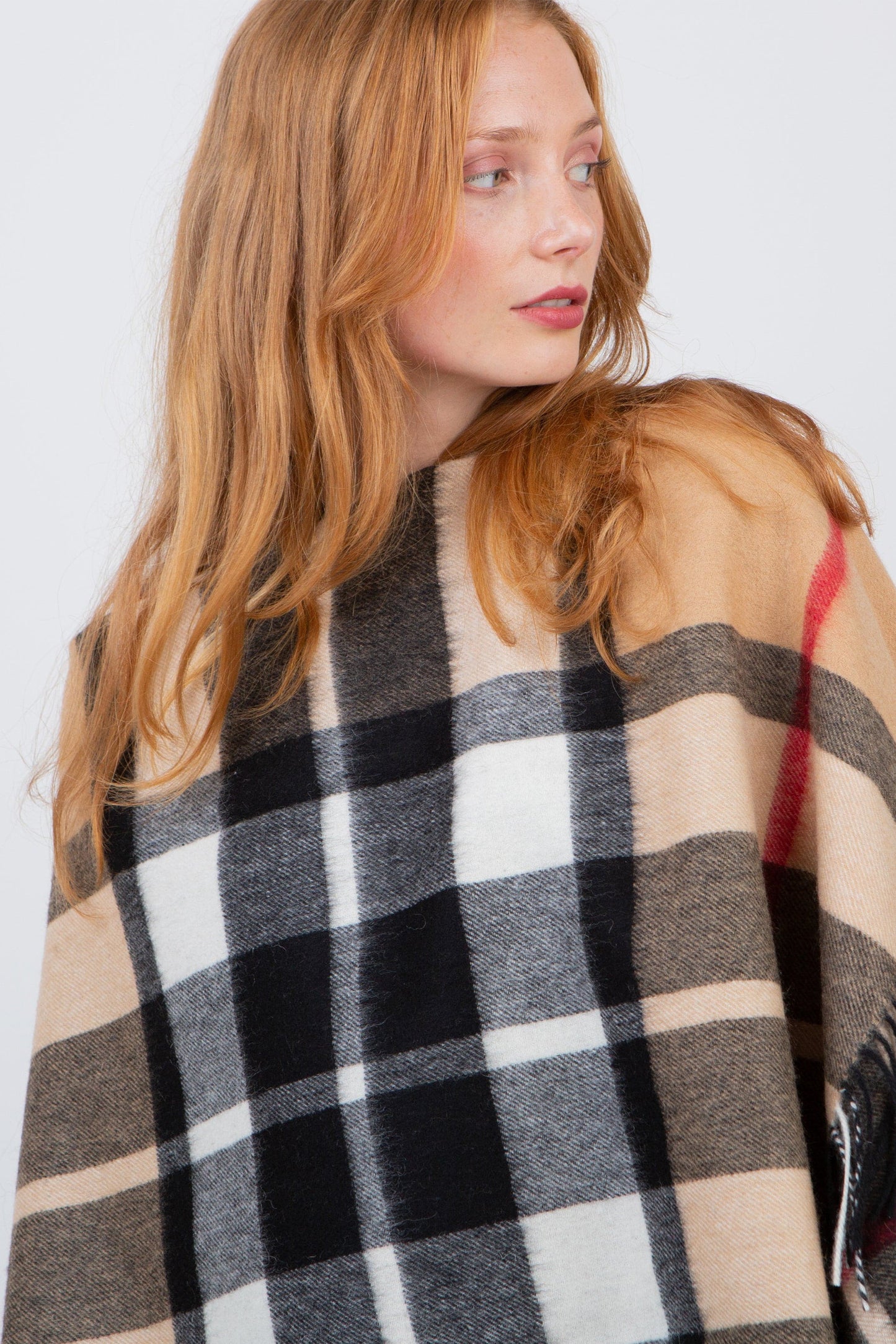 Close-up of Exploded Camel Thompson Lambswool Wrap worn over shoulders, showing the plaid pattern in camel, black, white, and red
