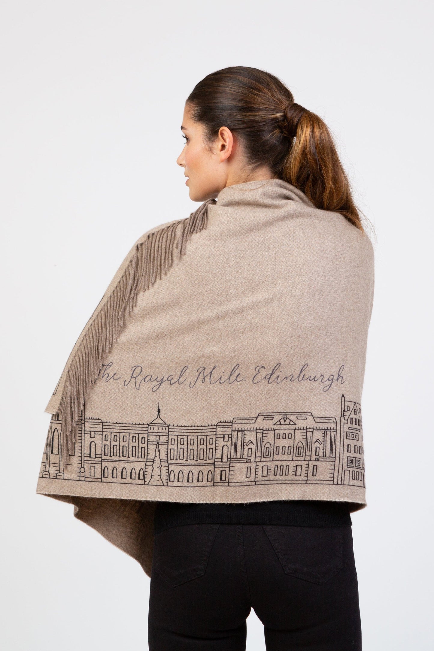 Back view of Royal Mile Cashmere Double Sided Stole in beige, showing Edinburgh skyline illustration and fringed edges draped over shoulders