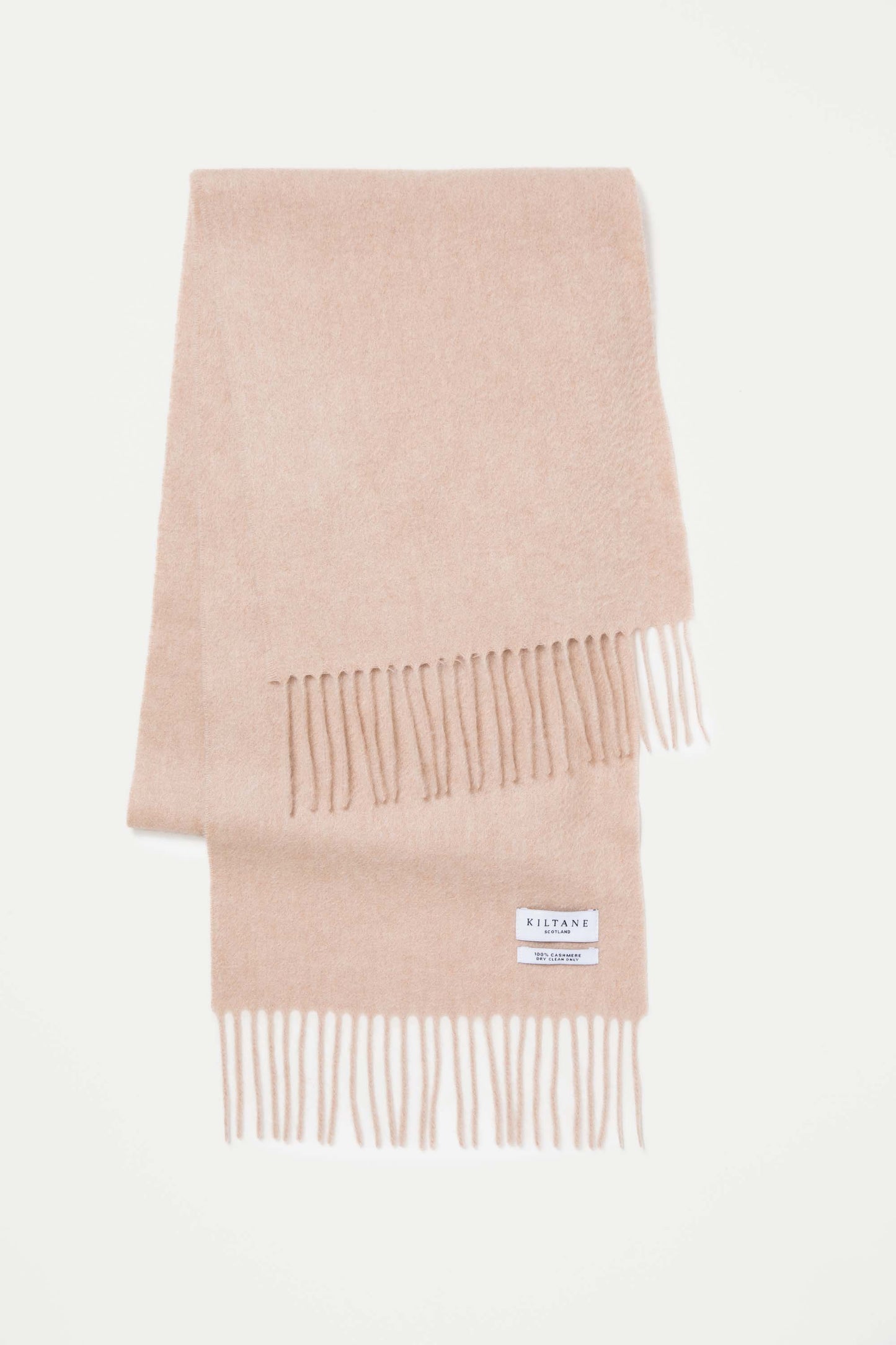 Kiltane Solid Cashmere Scarf in Vicuna folded flat showing soft beige tone, fringed ends, and brand label