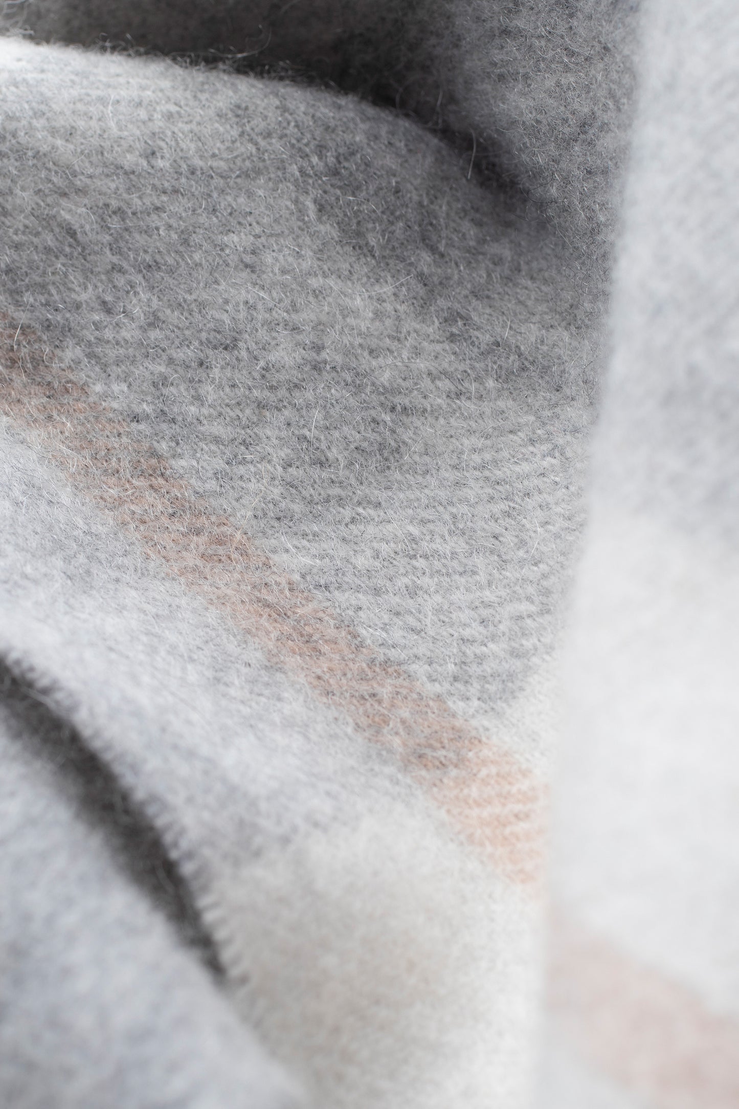 Close-up of the Contemporary Check Cashmere Scarf in Grey showing soft brushed texture with subtle blush pink check detail