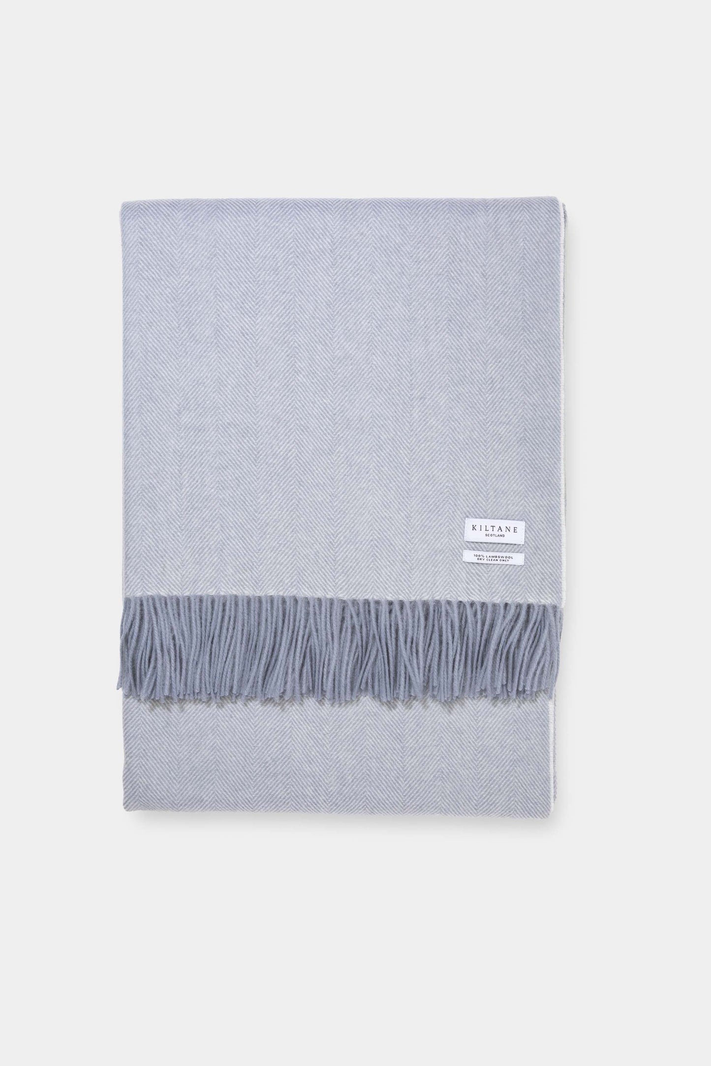 Kiltane Herringbone Lambswool Throw in Lulworth Blue, folded flat showing herringbone weave pattern and fringed edges