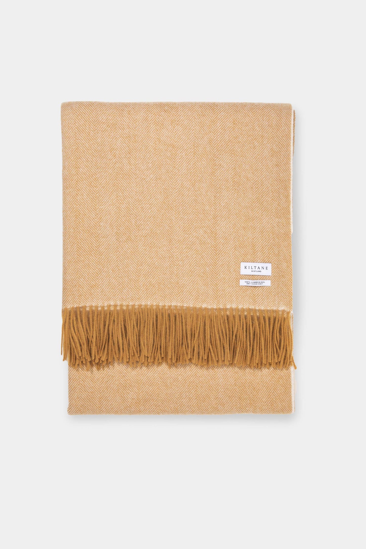 Kiltane Herringbone Lambswool Throw in Amber Gold, neatly folded showing herringbone weave pattern and fringed edge