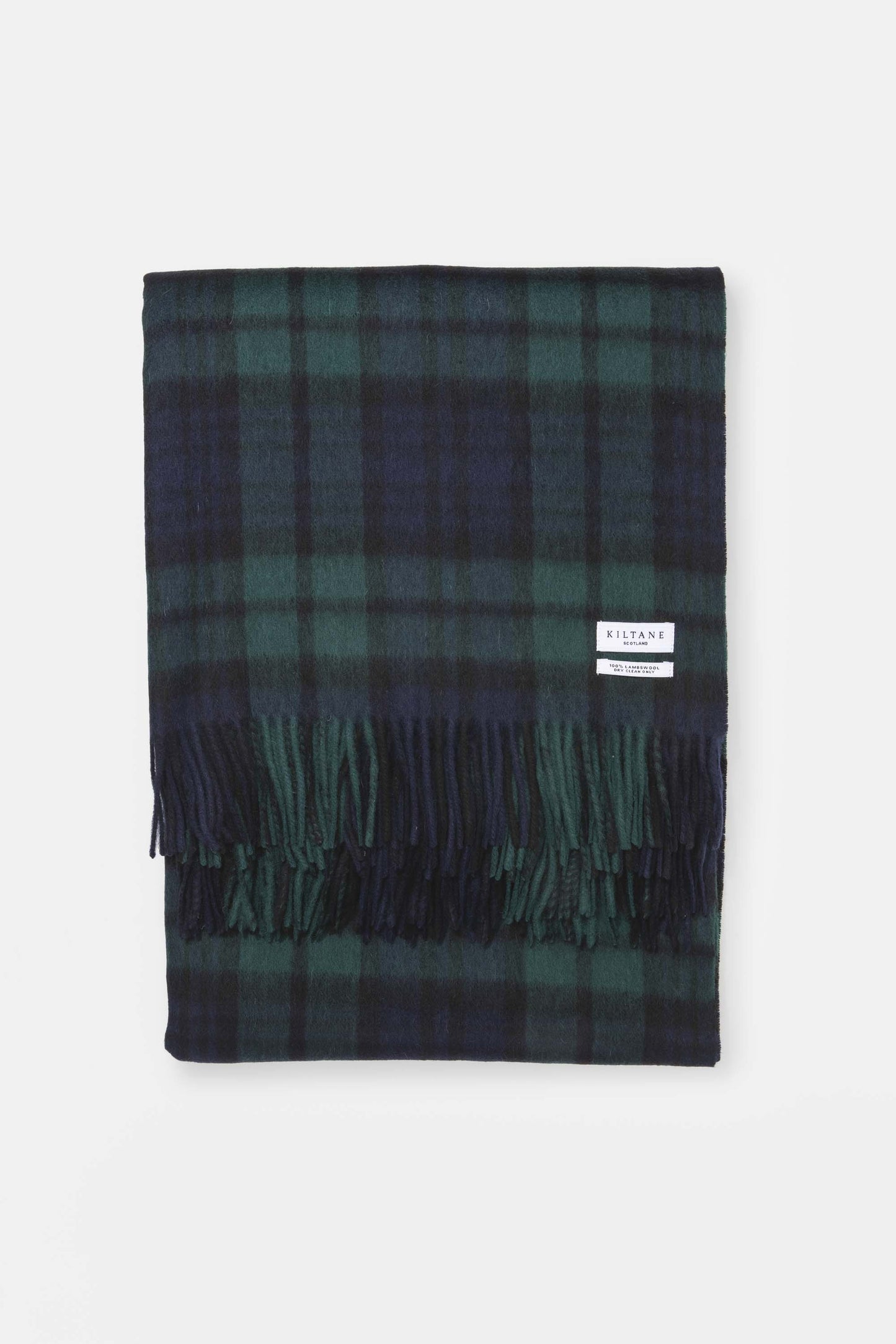 Kiltane Lambswool Throw in Blackwatch tartan, navy and green plaid pattern with fringed edges, neatly folded