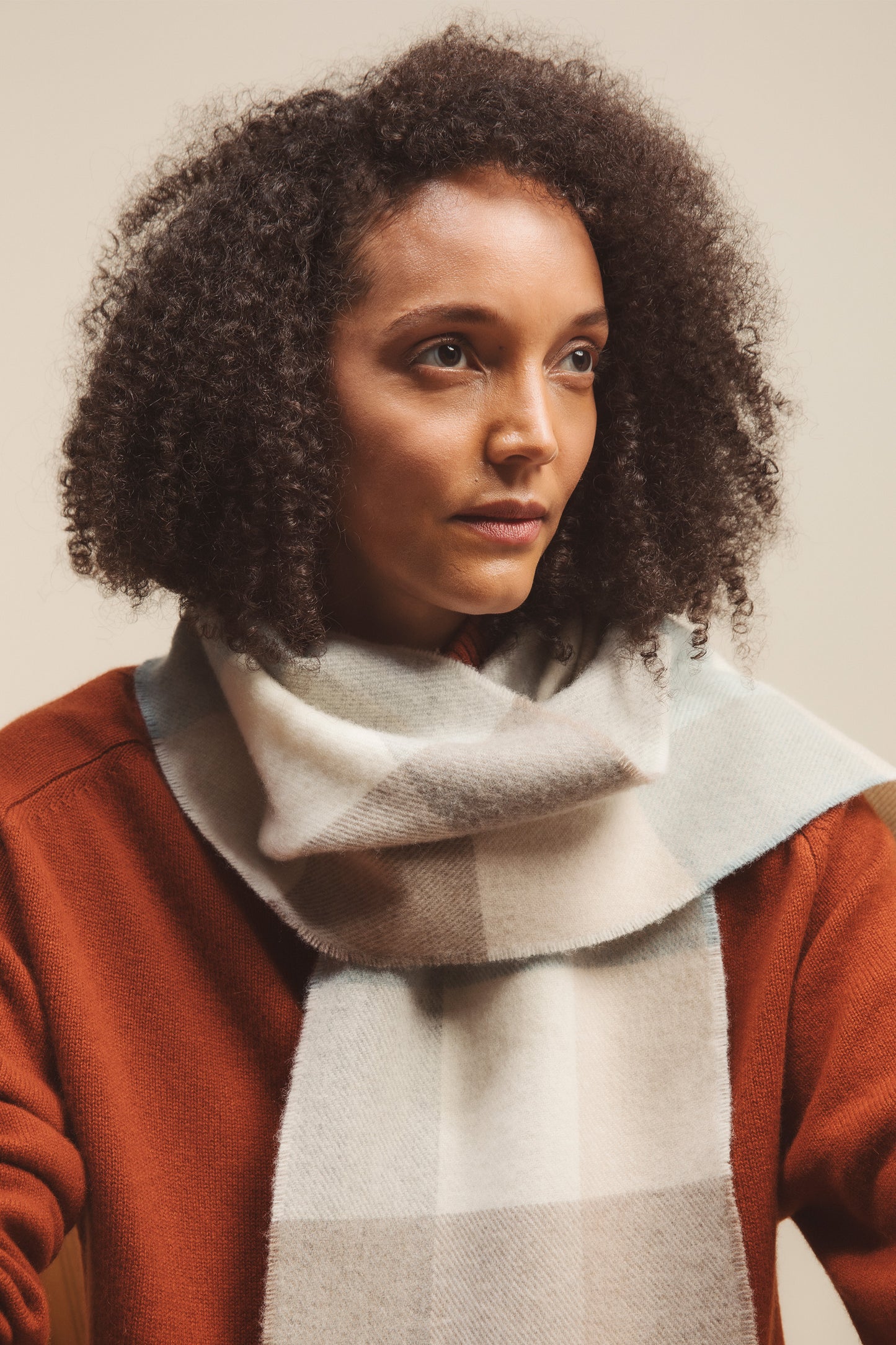 Made in Scotland Lambswool Scarf in Opal 3 Square Check worn wrapped around the neck, styled with a rust knit sweater
