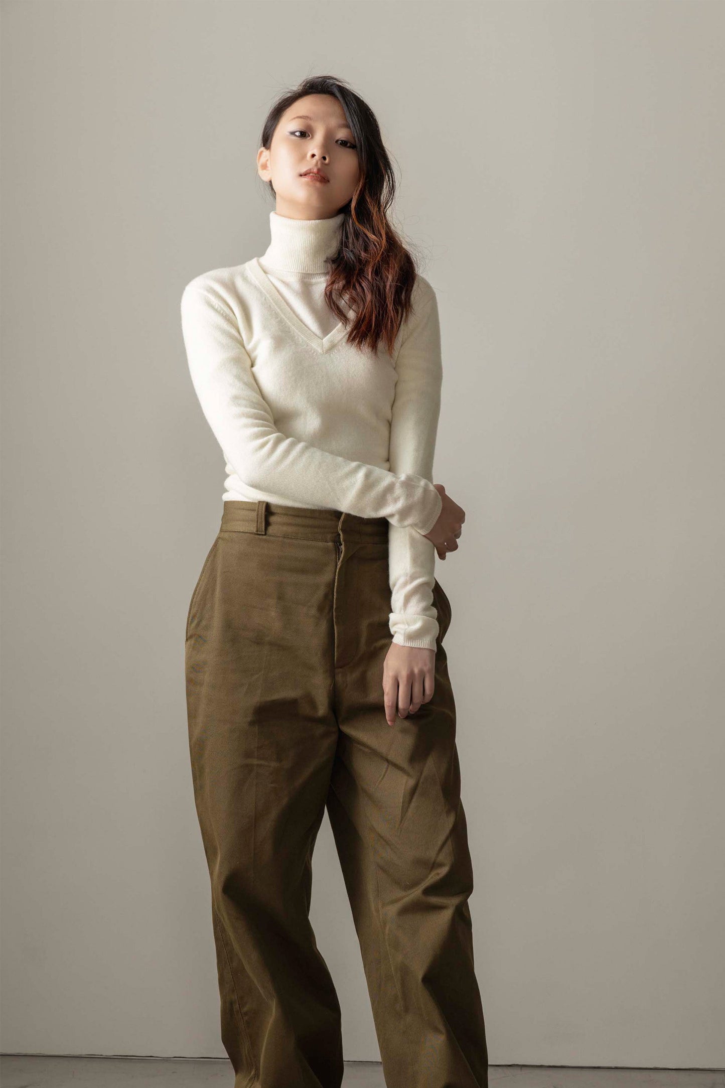 Women's Cashmere V Neck Jumper in Soft Cream, slim-fit lightweight knit with ribbed V-neckline, styled over a turtleneck