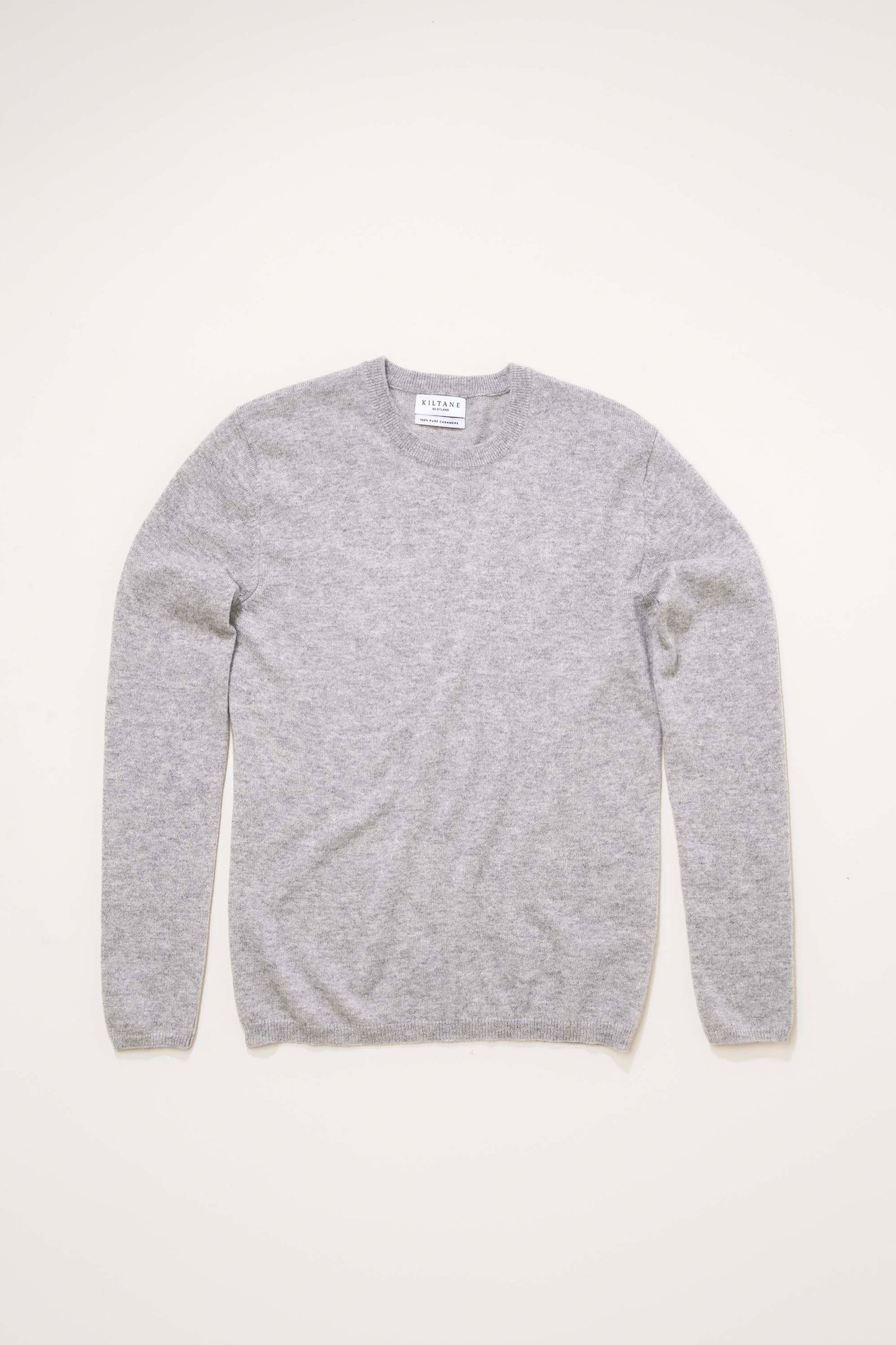 Kiltane Women's Cashmere Crew Neck Jumper in light grey laid flat, showing full front with ribbed neckline and cuffs