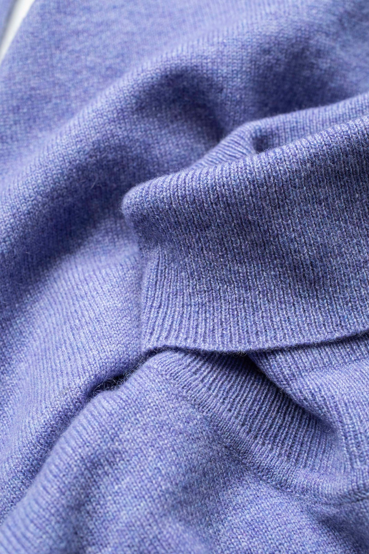 Close-up of the soft knit texture on the Women's Cashmere Polo Neck Jumper in Wisteria, showing fine ribbed weave detail