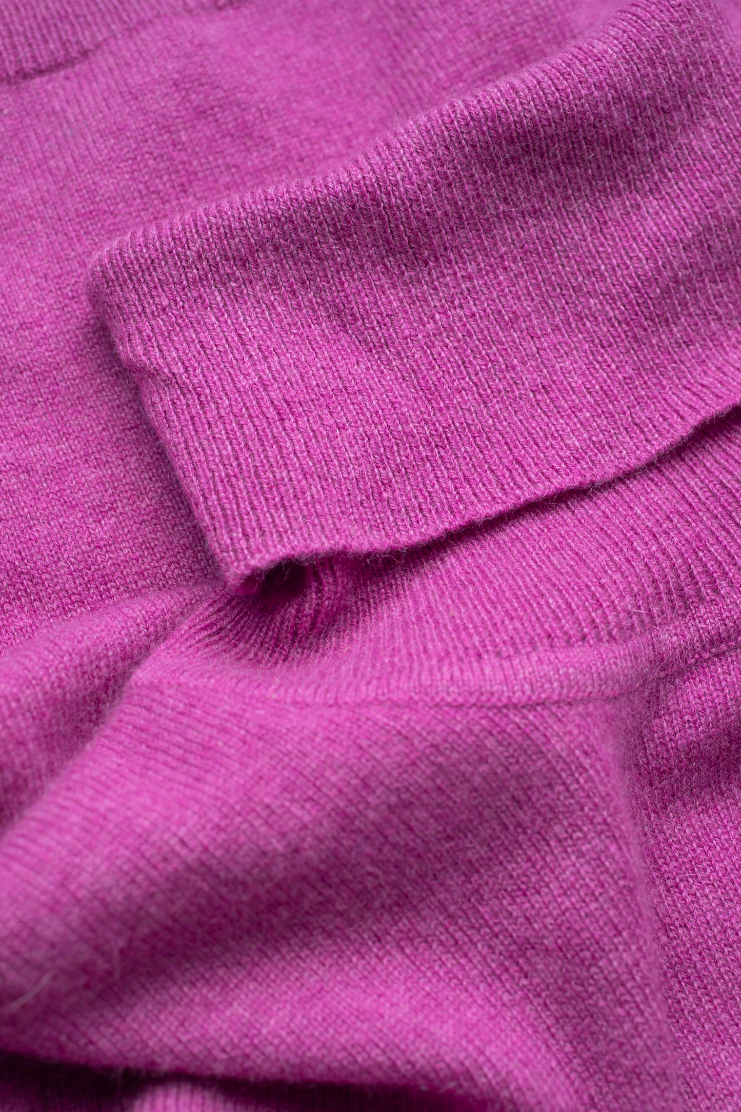 Close-up of the fine-knit cashmere texture on the Women's Cashmere Polo Neck Jumper in raspberry