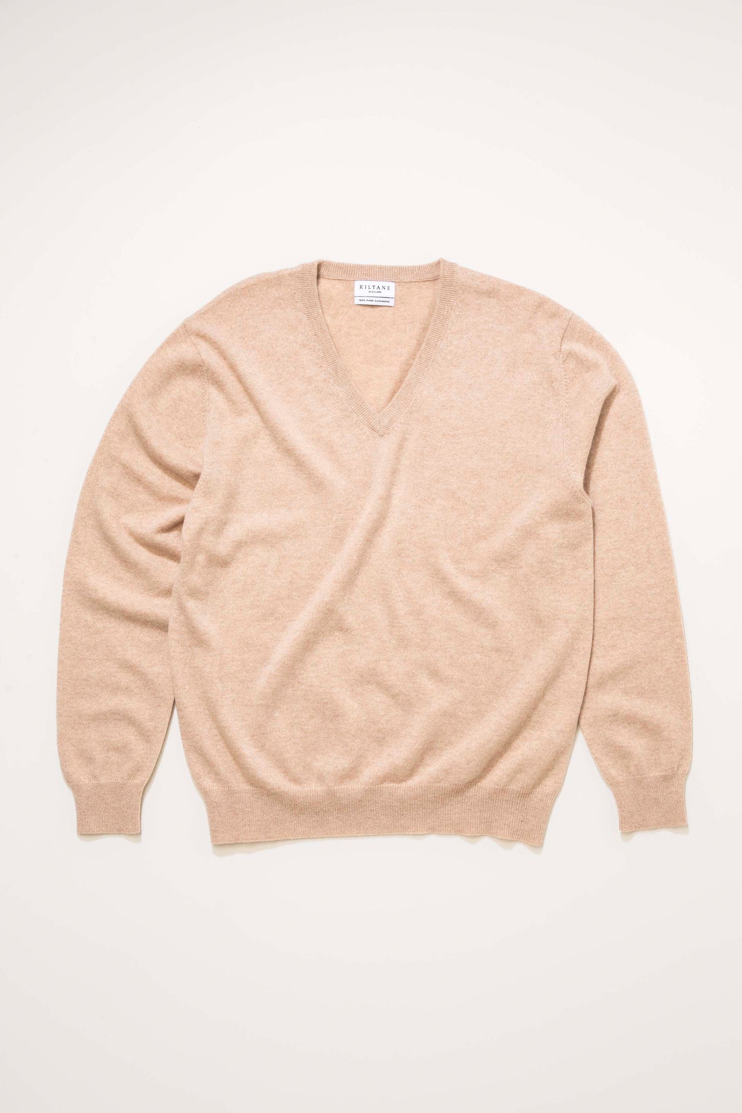 Kiltane Men's Cashmere V Neck Jumper in Vicuna laid flat, showing the soft camel-toned knit and ribbed cuffs