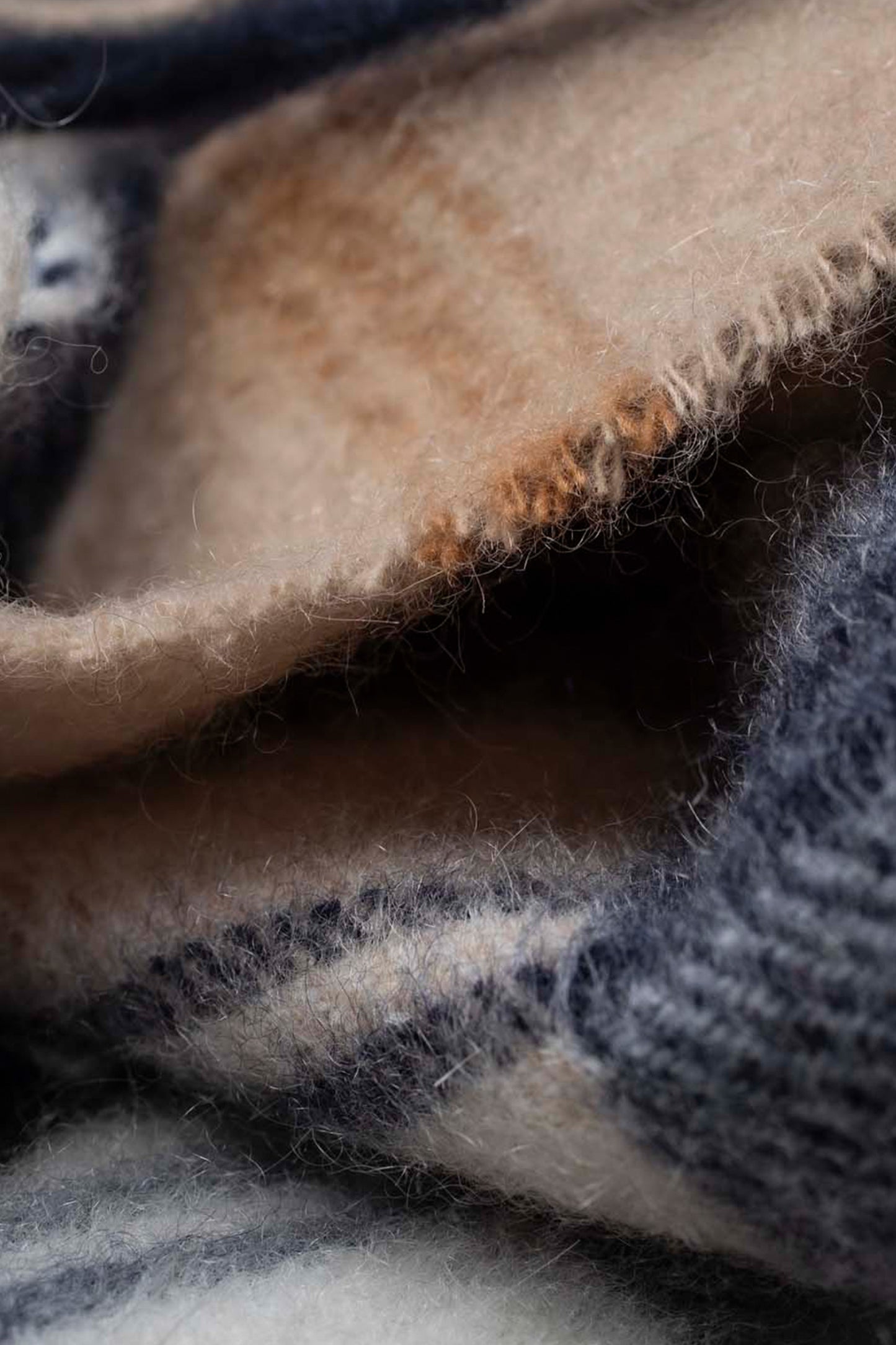 Close-up of the soft cashmere texture on the Made In Scotland Contemporary Cashmere Scarf in navy and camel tones