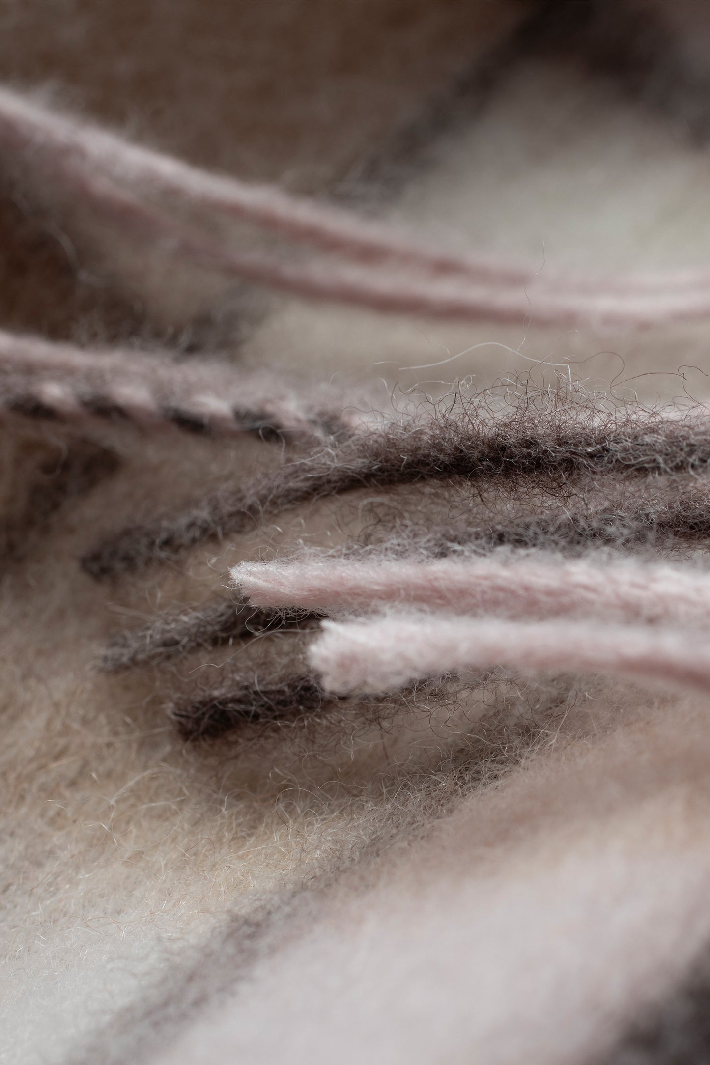 Close-up of Square Check Lambswool Scarf in Natural showing soft fuzzy texture and pink, brown, and cream stripe detail
