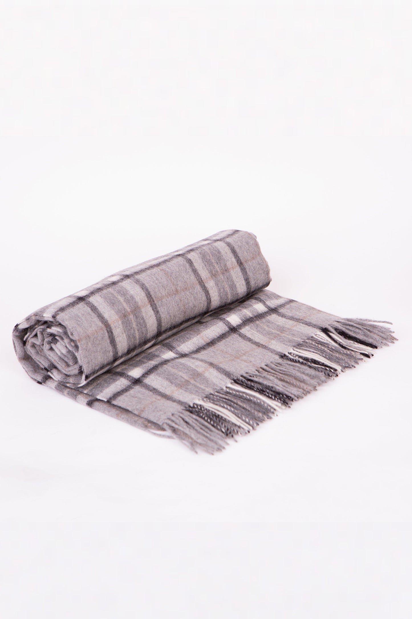 Lambswool Throw in Pewter Scotty Thompson, rolled to show grey and charcoal tartan pattern with fringed edges