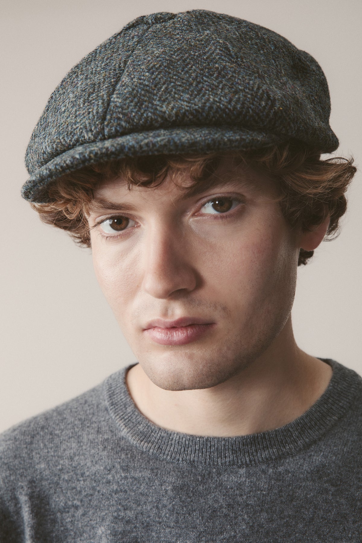 Harris Tweed Carloway Hat in Blue Mix Herringbone worn by model, front-facing close-up showing the panelled crown and brim