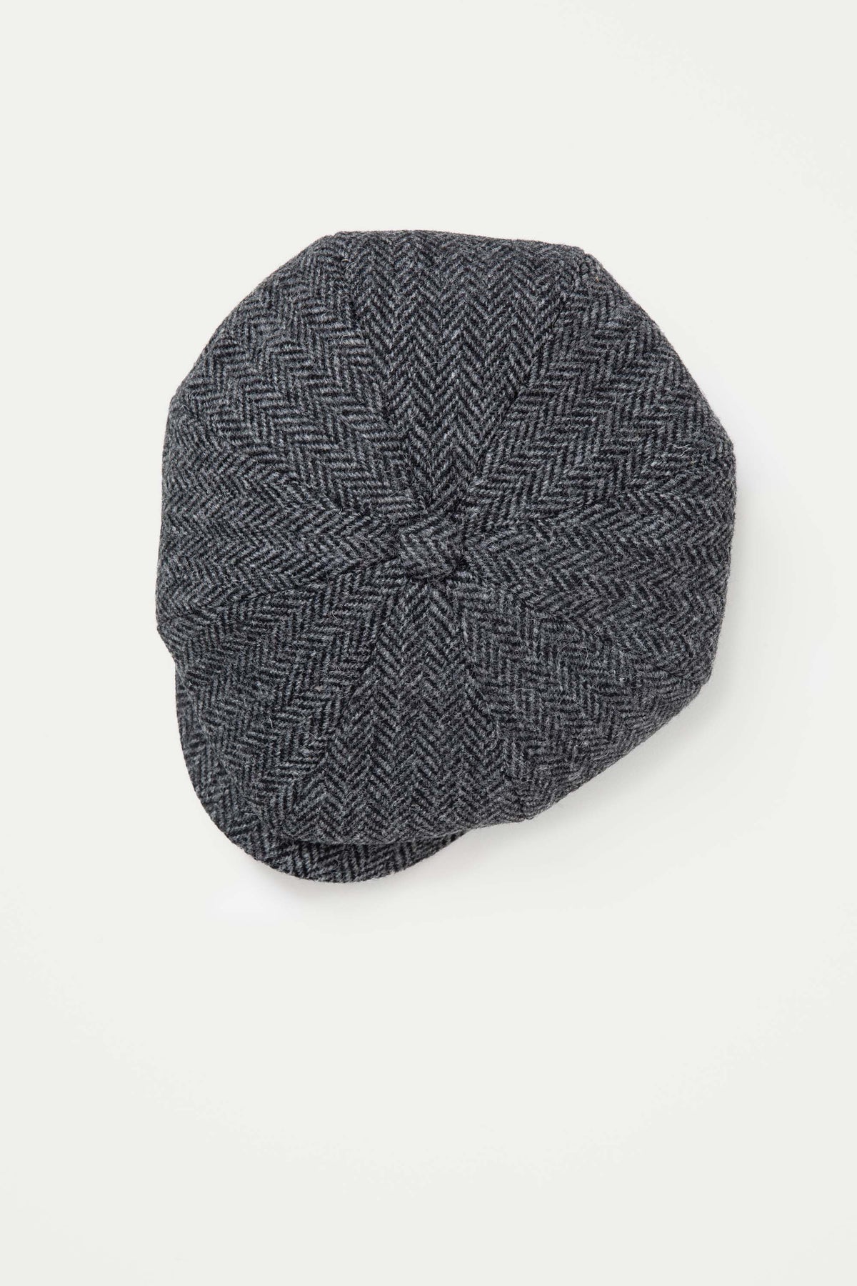 Top-down view of the Harris Tweed Carloway Hat showing the charcoal herringbone panel construction and centre button