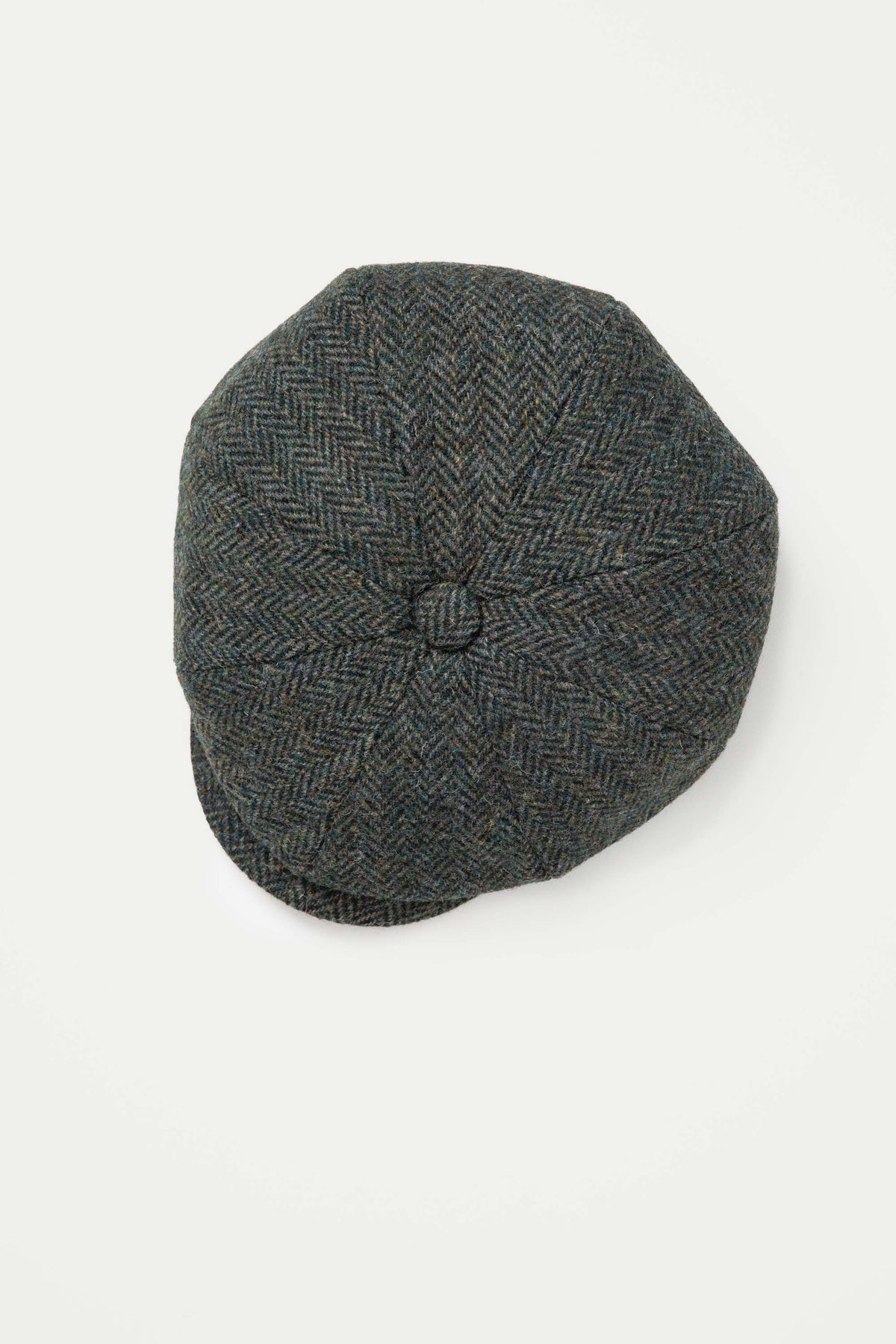 Top-down view of the Harris Tweed Carloway Hat showing eight-panel crown construction with centre button in dark green herringbone