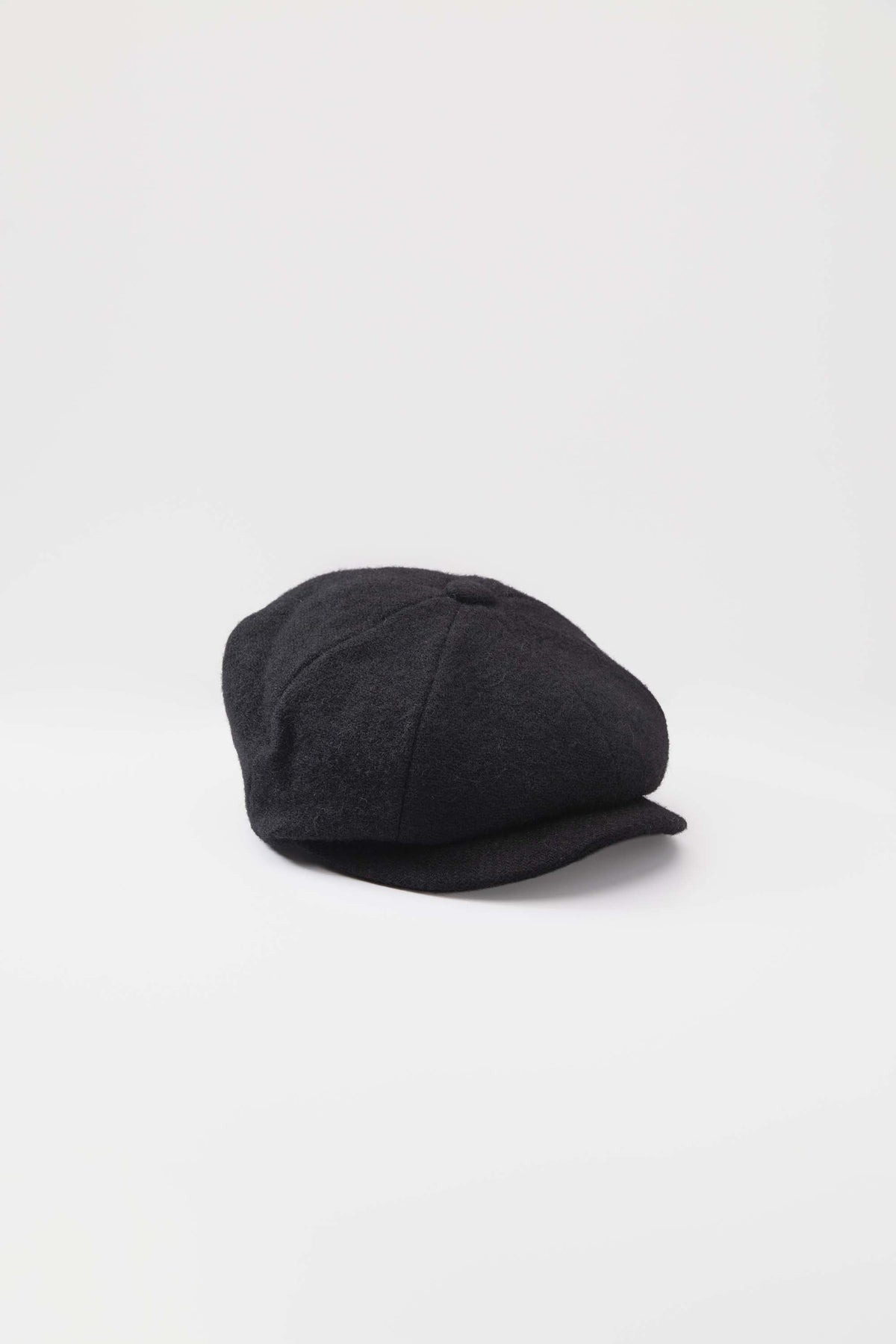 Harris Tweed Carloway Hat in plain black twill, three-quarter view showing panelled crown and short brim