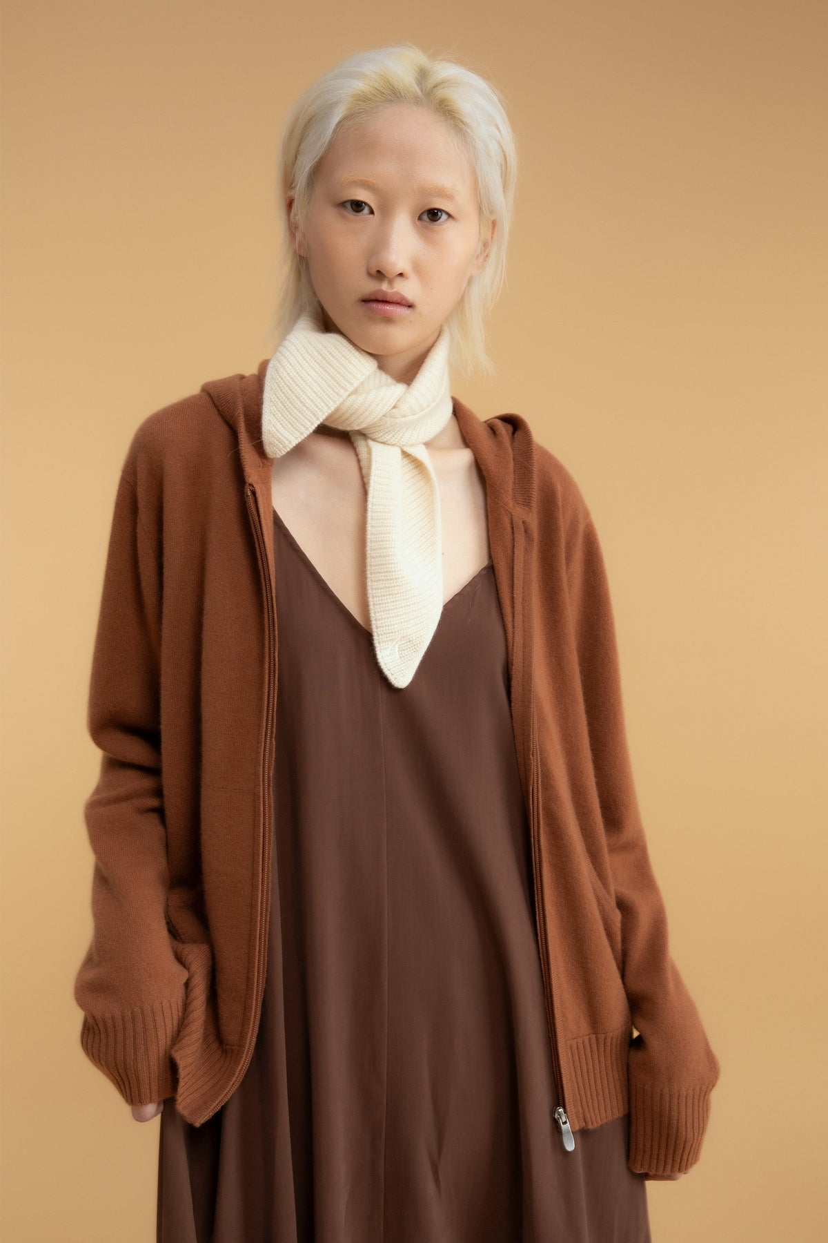 Knitted Cashmere Neck Tie in Cream styled knotted at the neck over a brown slip dress and camel zip-up cardigan