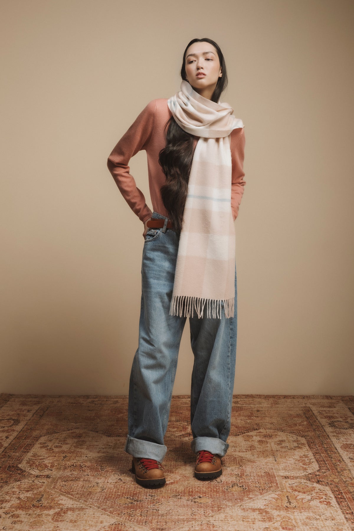 Contemporary Check Cashmere Wide Scarf in Champagne Pink worn wrapped around the neck, showing plaid pattern and fringed ends