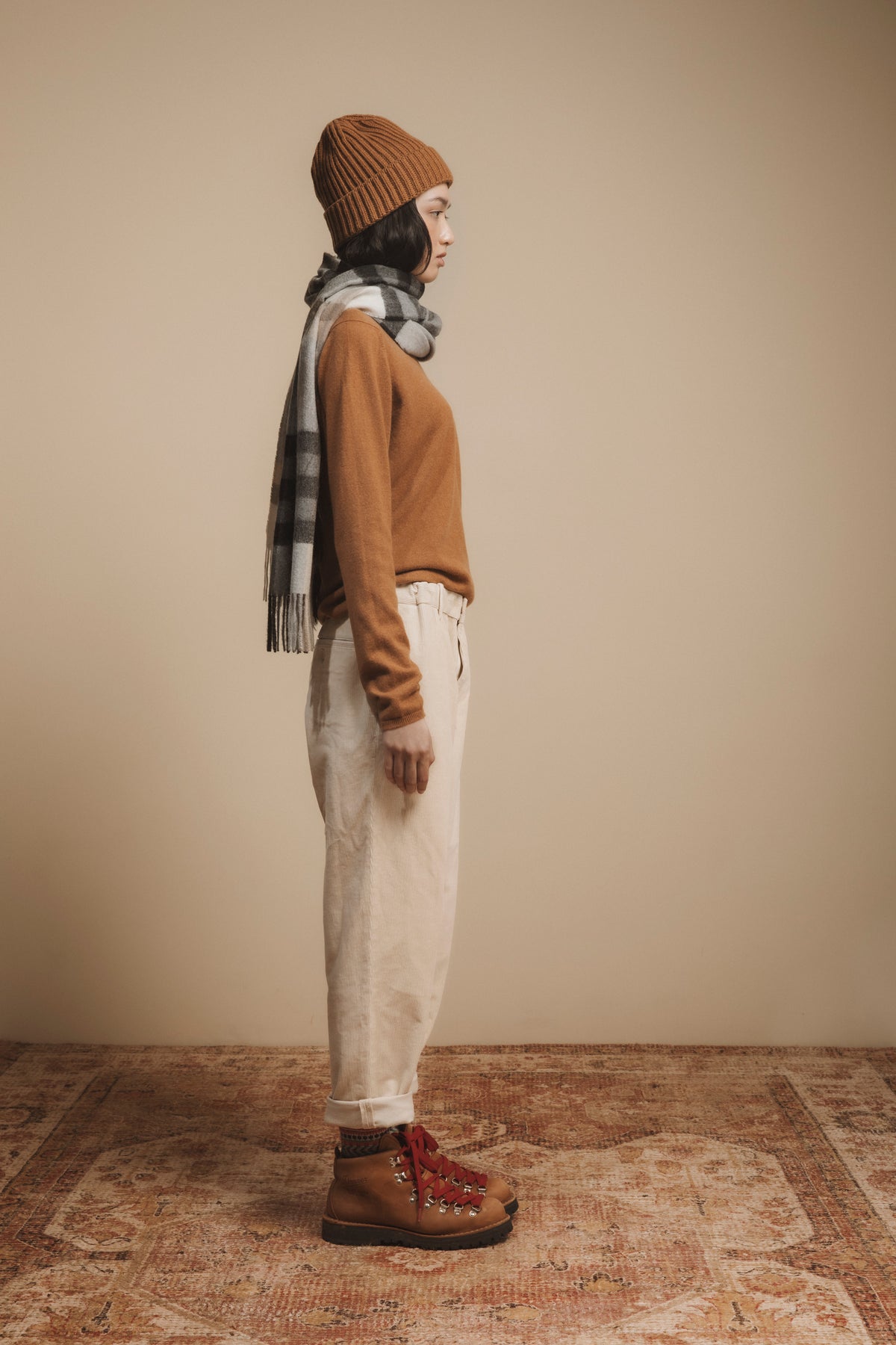 Made in Scotland Tartan 2 Cashmere Wide Scarf in Black Grey, worn draped over shoulder with fringed ends, styled with autumn layers