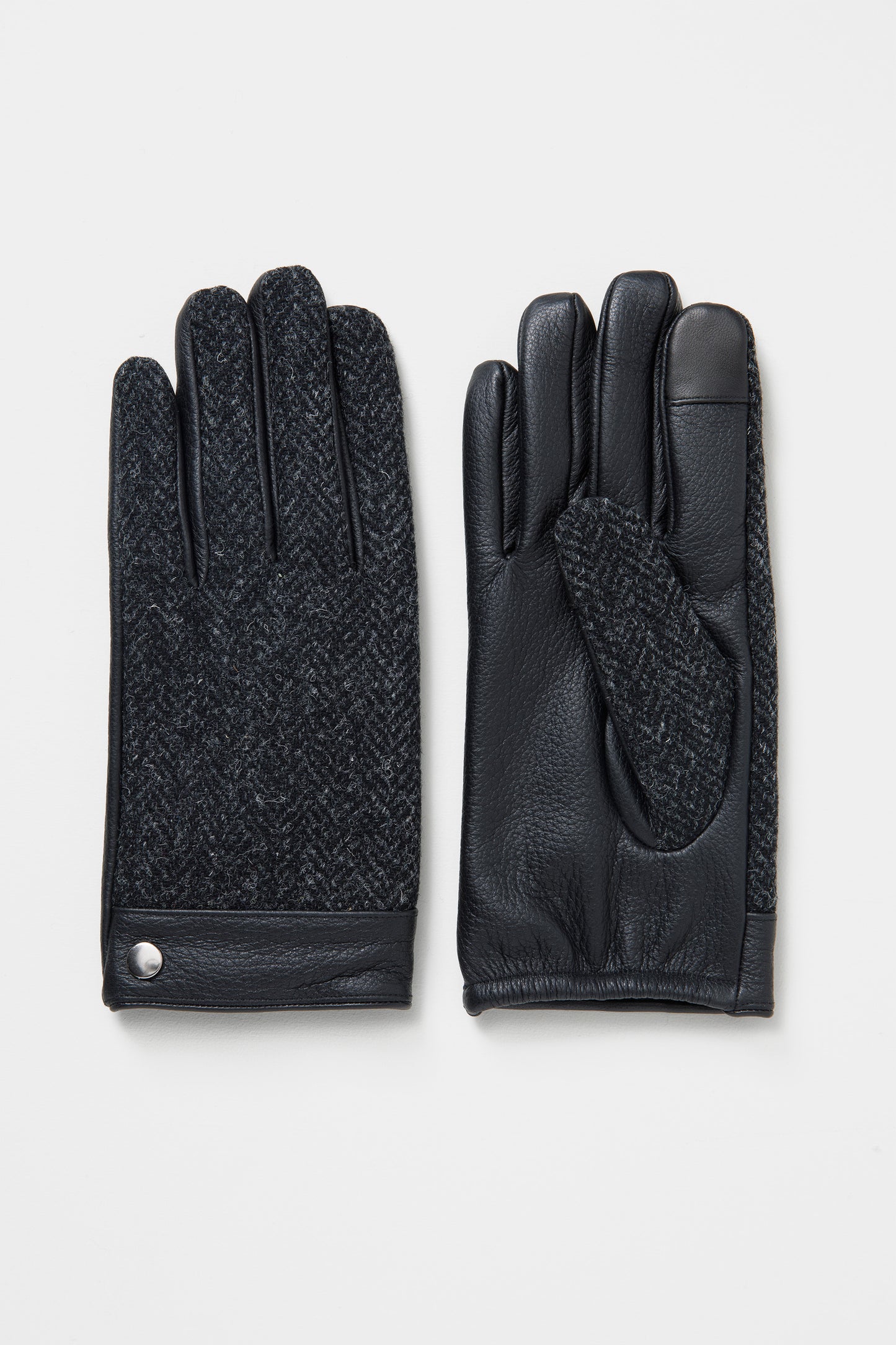 Men's Harris Tweed Gloves in Deep Charcoal showing herringbone tweed back and black leather palm with silver snap detail
