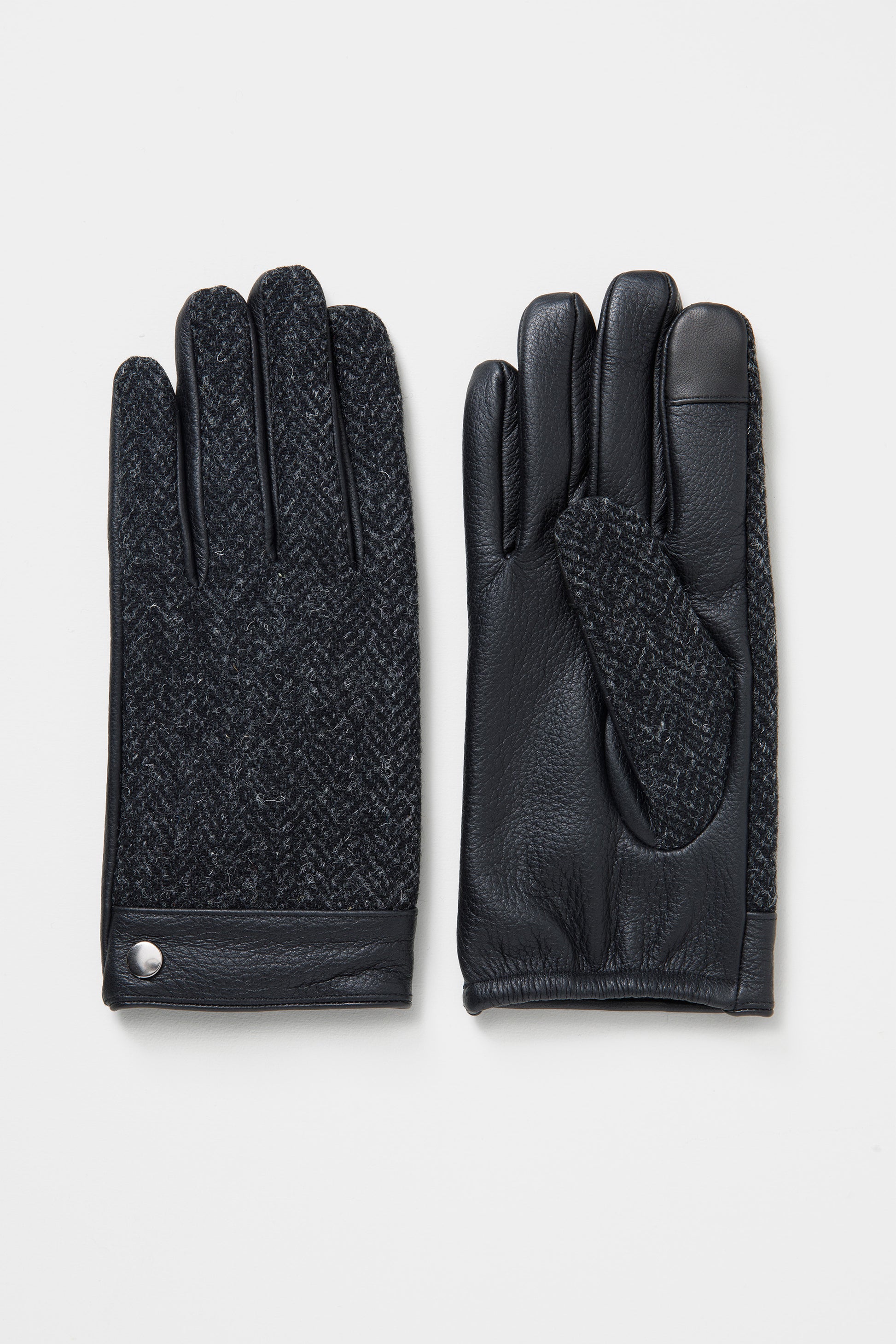 Men's Harris Tweed Gloves in Deep Charcoal showing herringbone tweed back and black leather palm with silver snap detail