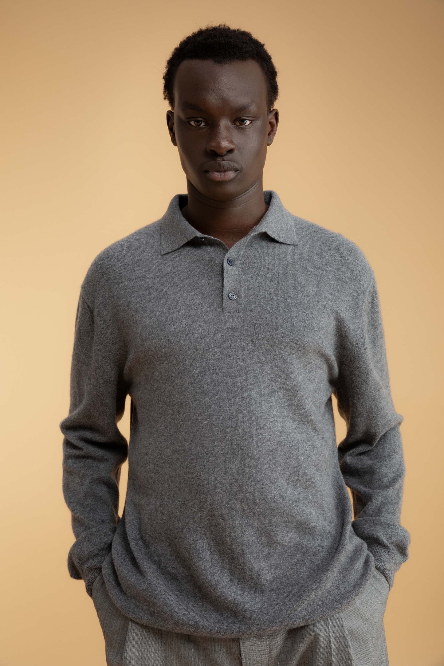 Model wearing Men's Long Sleeved Knitted Polo Shirt in Derby Grey, front view showing collar and three-button placket detail