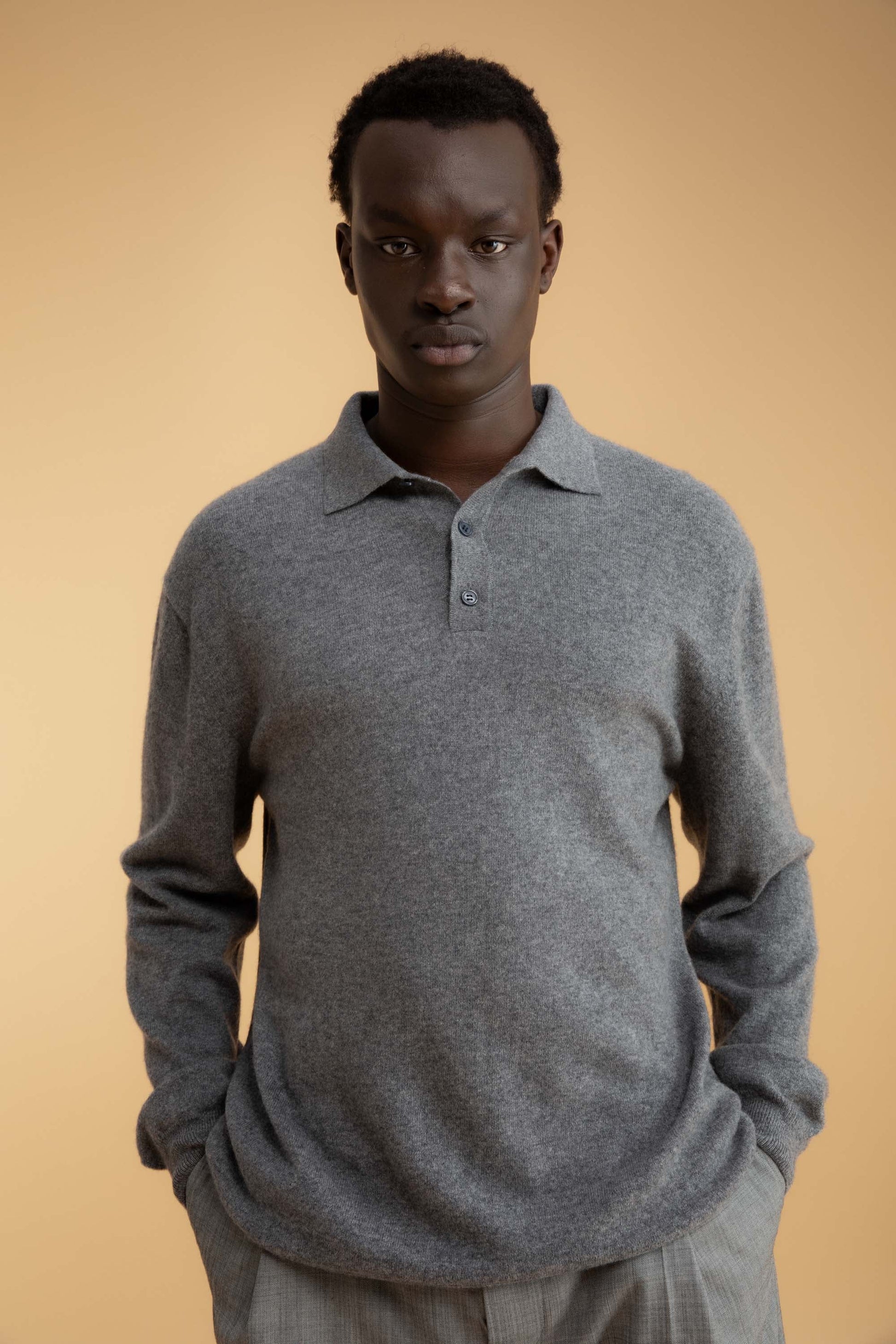 Model wearing Men's Long Sleeved Knitted Polo Shirt in Derby Grey, front view showing collar and three-button placket detail
