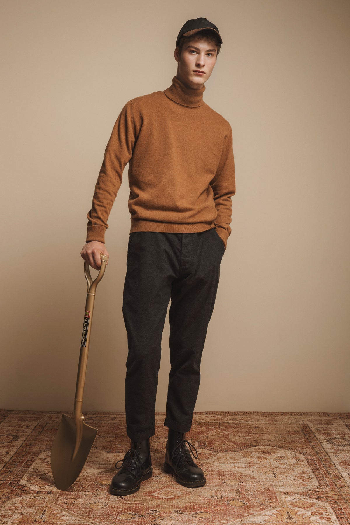 Wax Baseball Cap in black worn by model styled with camel turtleneck sweater, dark trousers, and black boots
