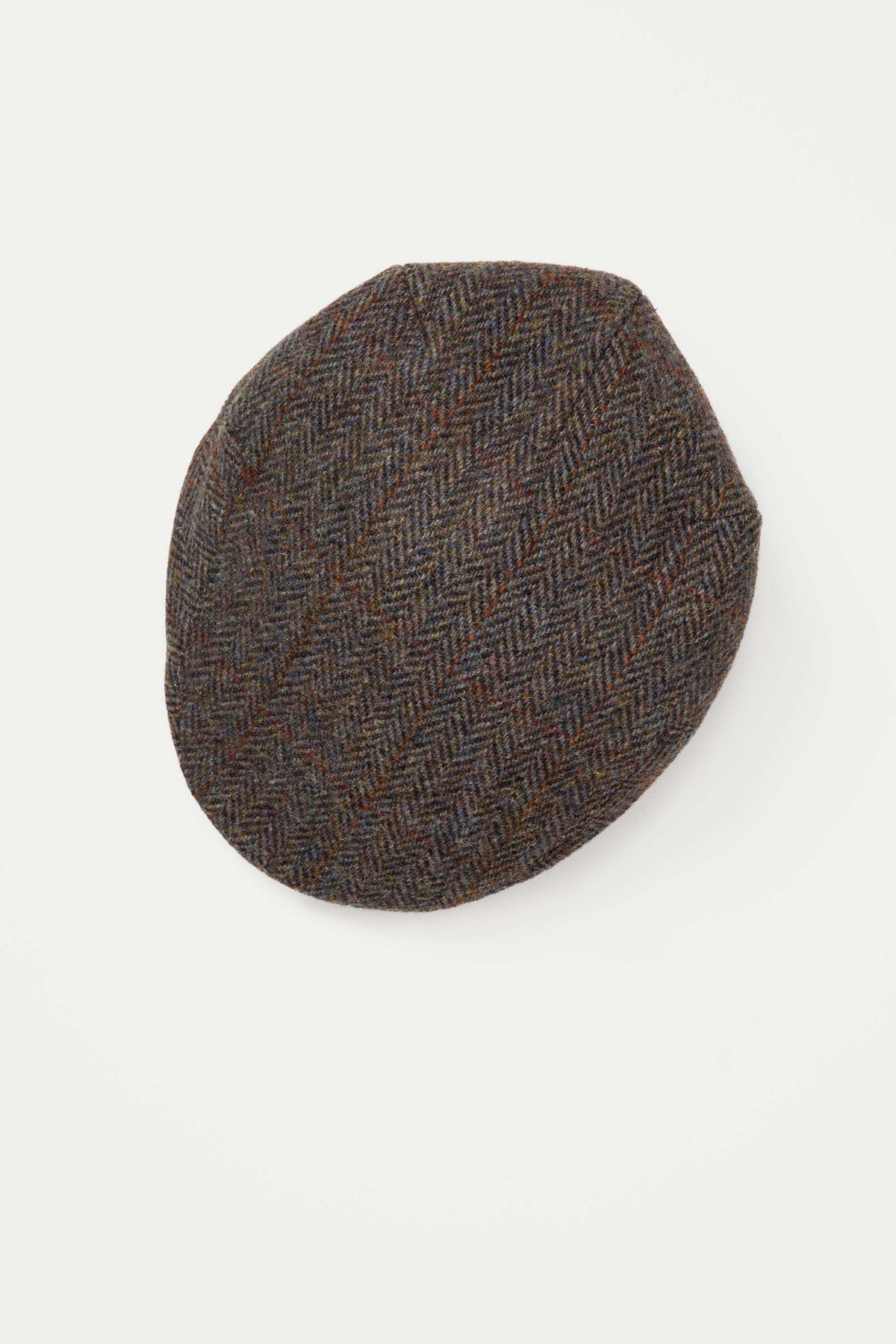 Harris Tweed Stornoway Cap in Brown Check viewed from above, showing the herringbone weave pattern and flat crown