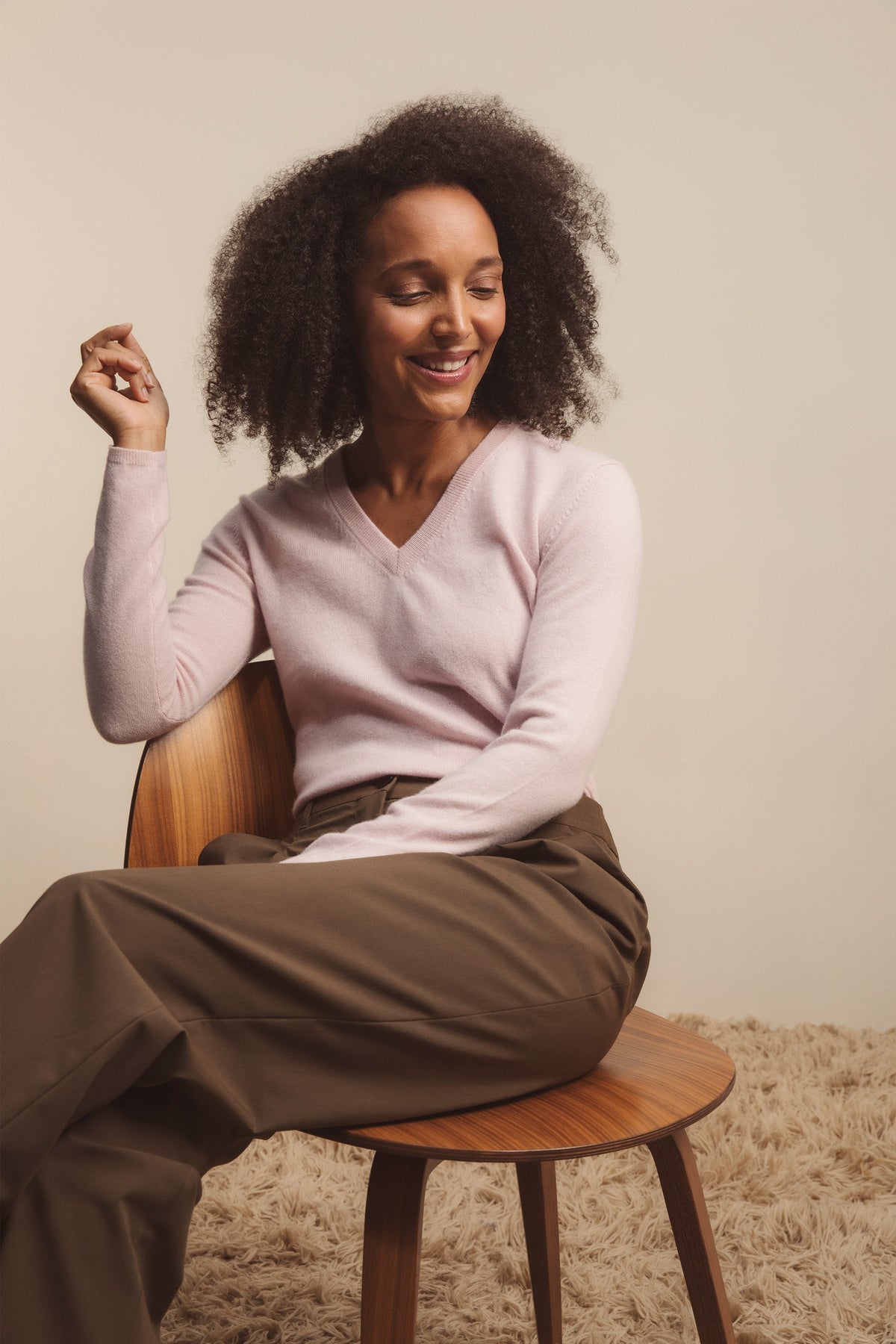 Model seated wearing Women's Cashmere V Neck Jumper in Pale Lilac, showing the relaxed fit and soft V-neckline