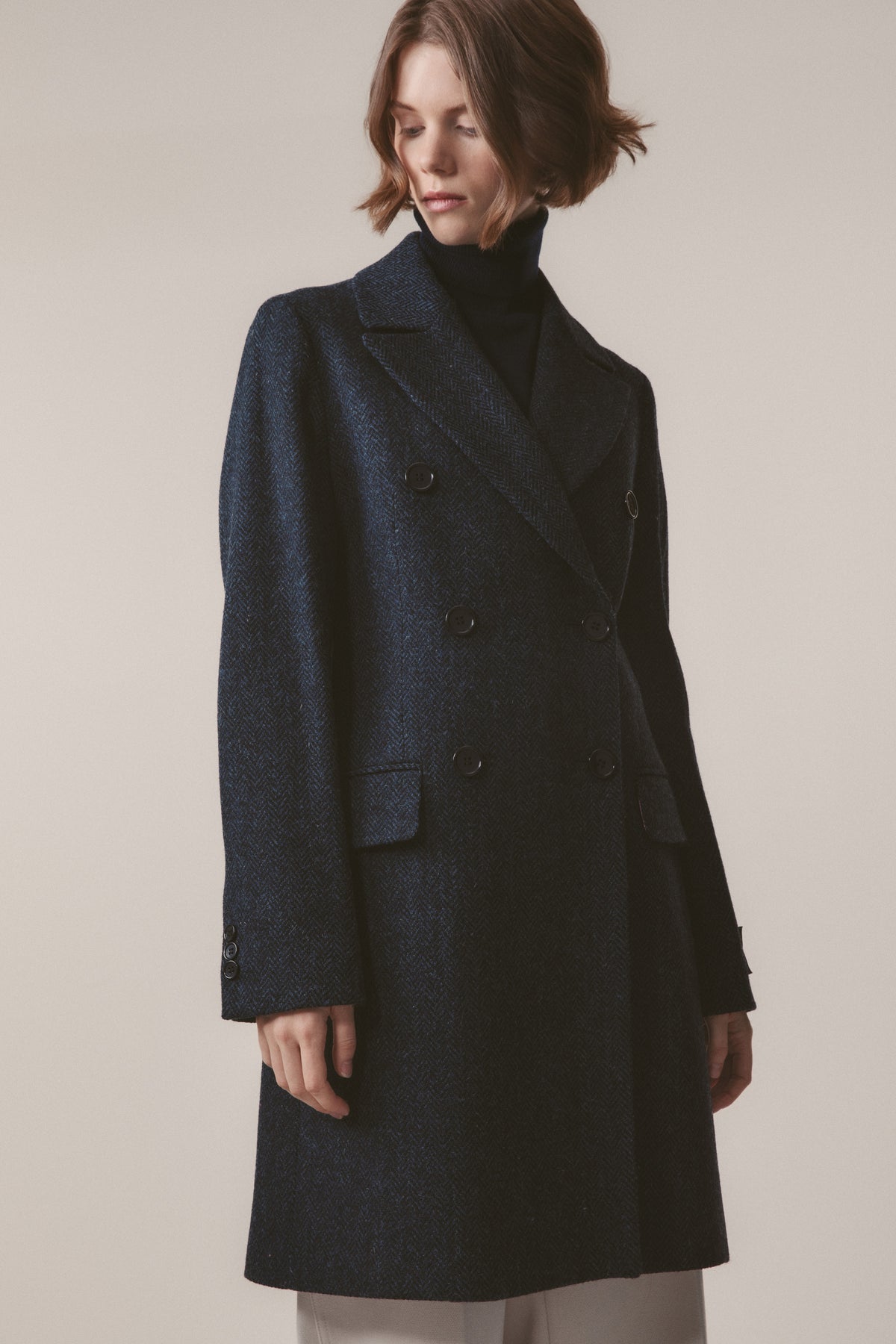 Women's Harris Tweed Melody Coat in dark navy blue herringbone, front view showing double-breasted button closure and peak lapels