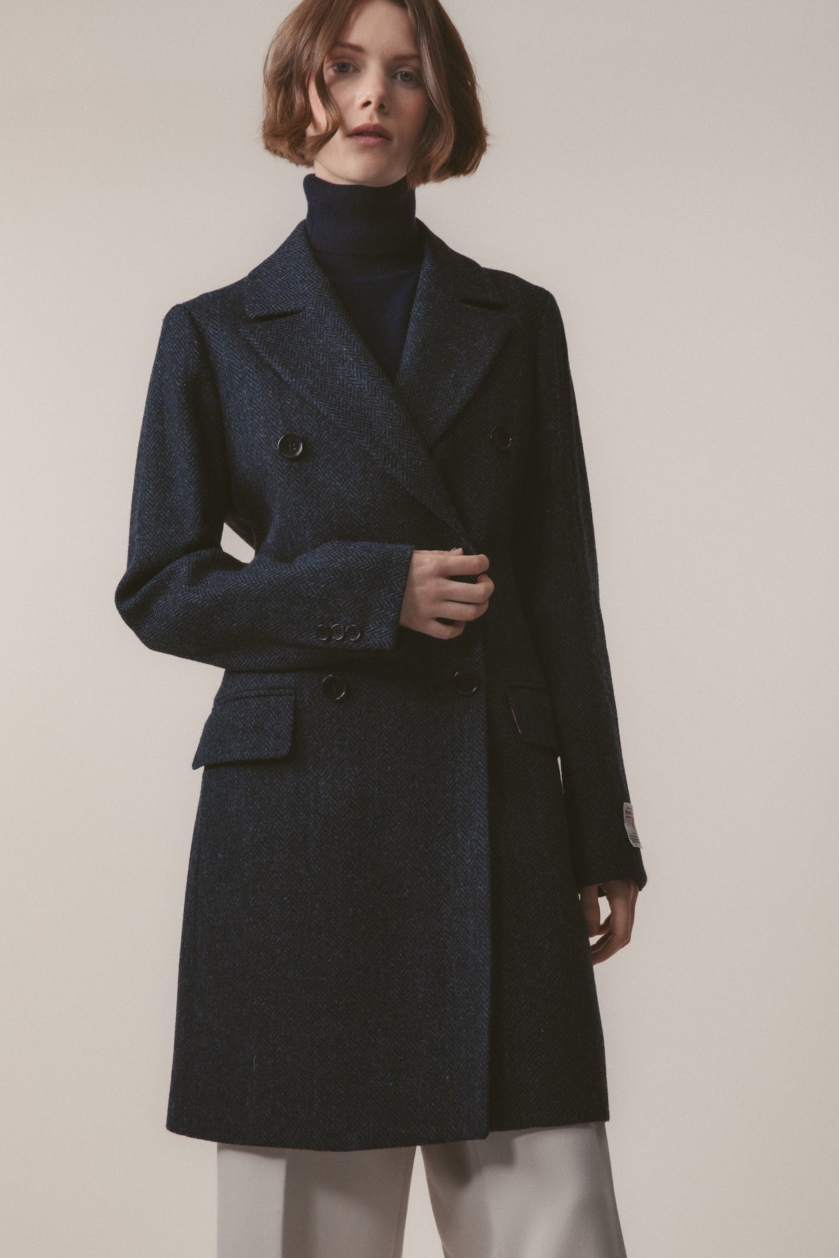 Women's Harris Tweed Melody Coat in dark navy blue herringbone, front view showing double-breasted button closure and flap pockets