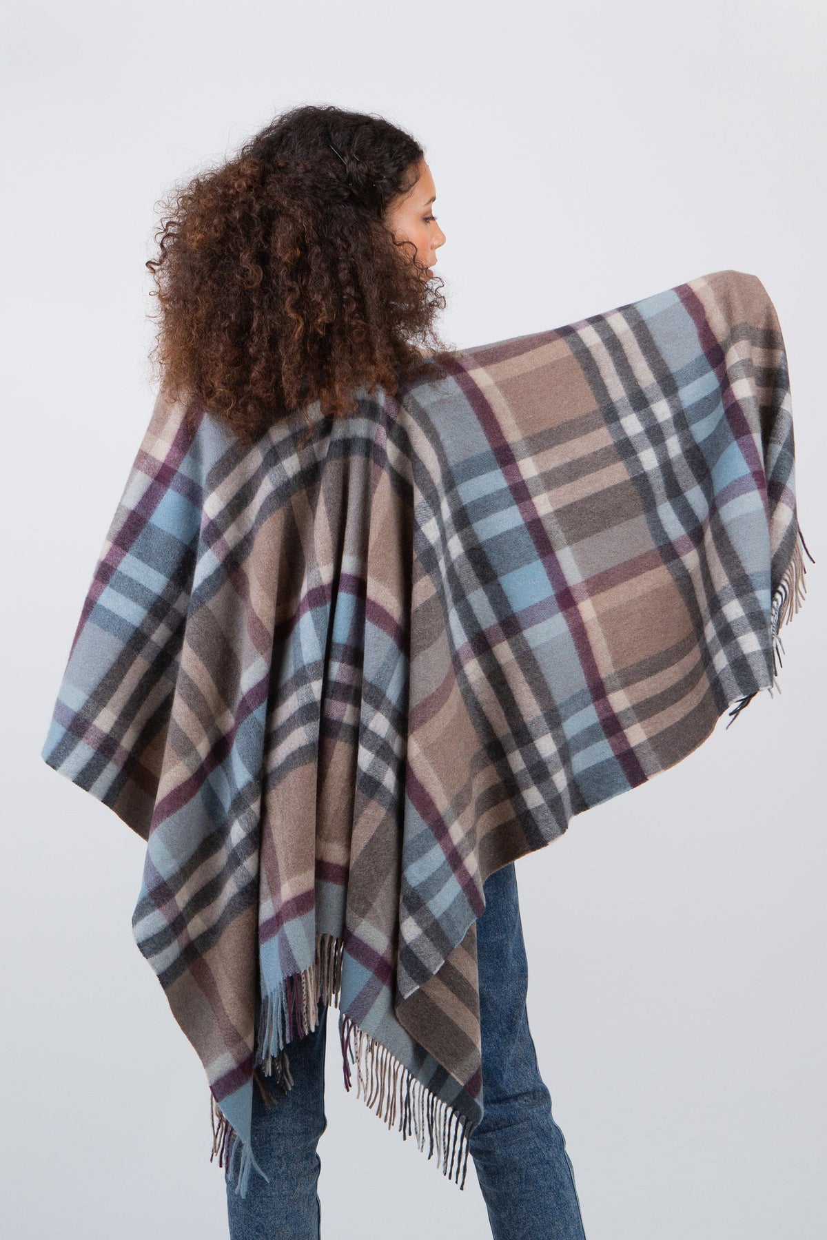Back view of Tartan 2 Cashmere Wrap in Blue Taupe, model with arms spread showing full plaid pattern and fringed edges