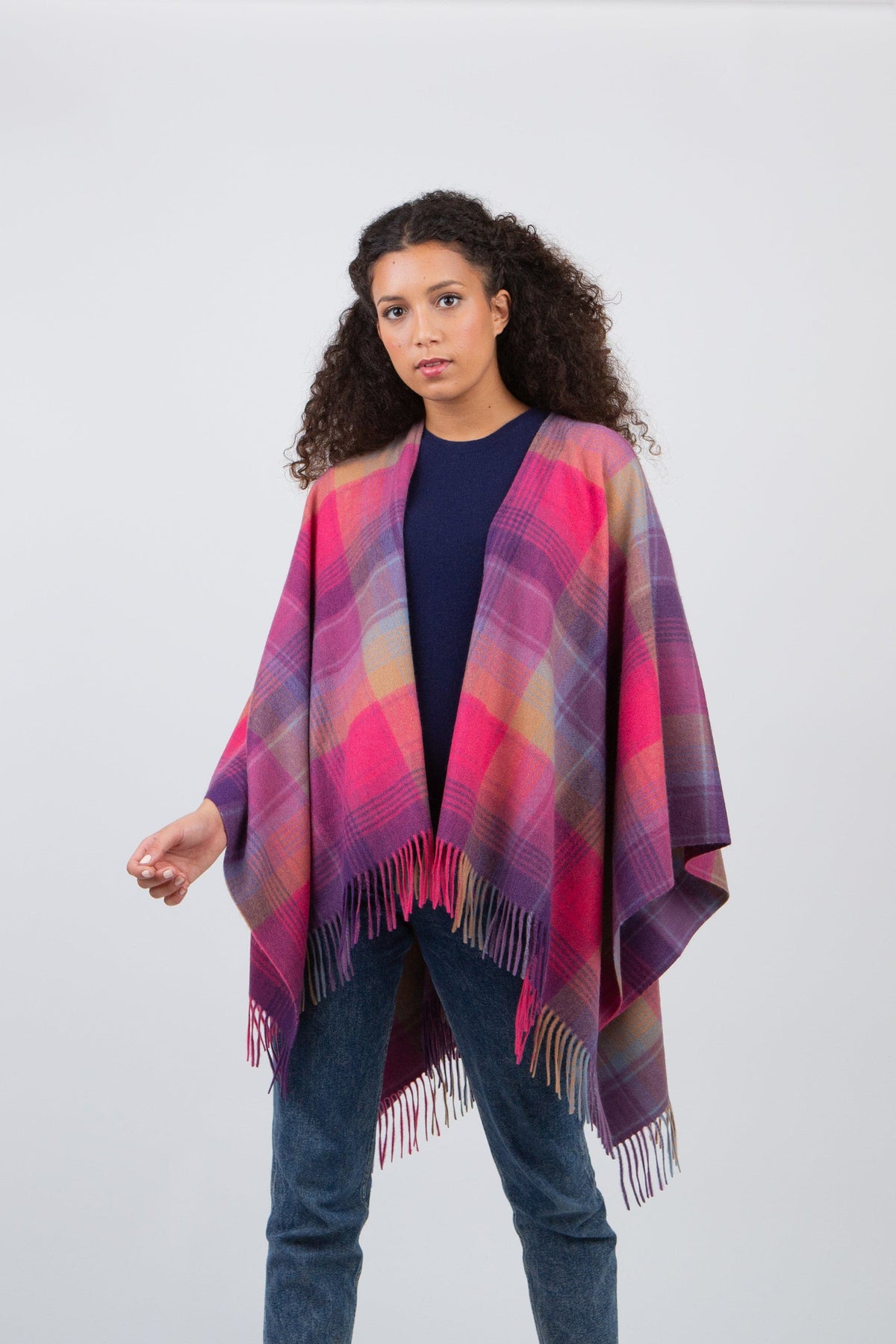 Repeat Edge Cashmere Wrap in pink and purple tartan plaid with fringed hem, worn open over a navy top