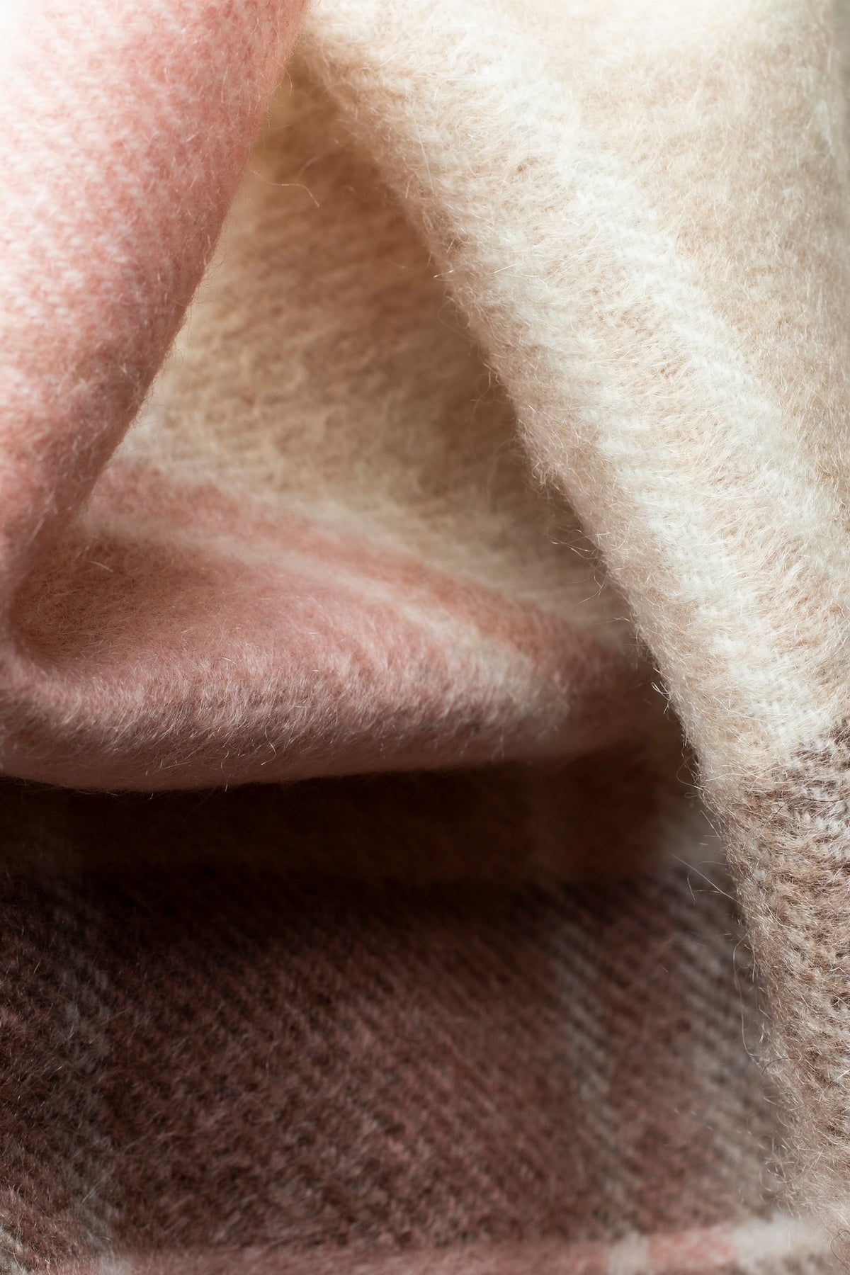 Close-up of Repeat Edge Cashmere Wrap in Natural showing soft brushed texture in pink, cream, and brown tartan
