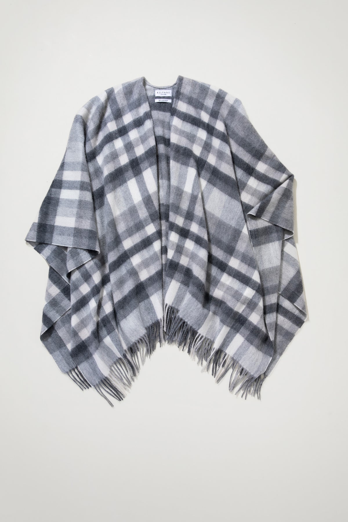 Stepping Check Cashmere Wrap in Monochrome laid flat showing open-front drape, grey and white plaid pattern, and fringed hem