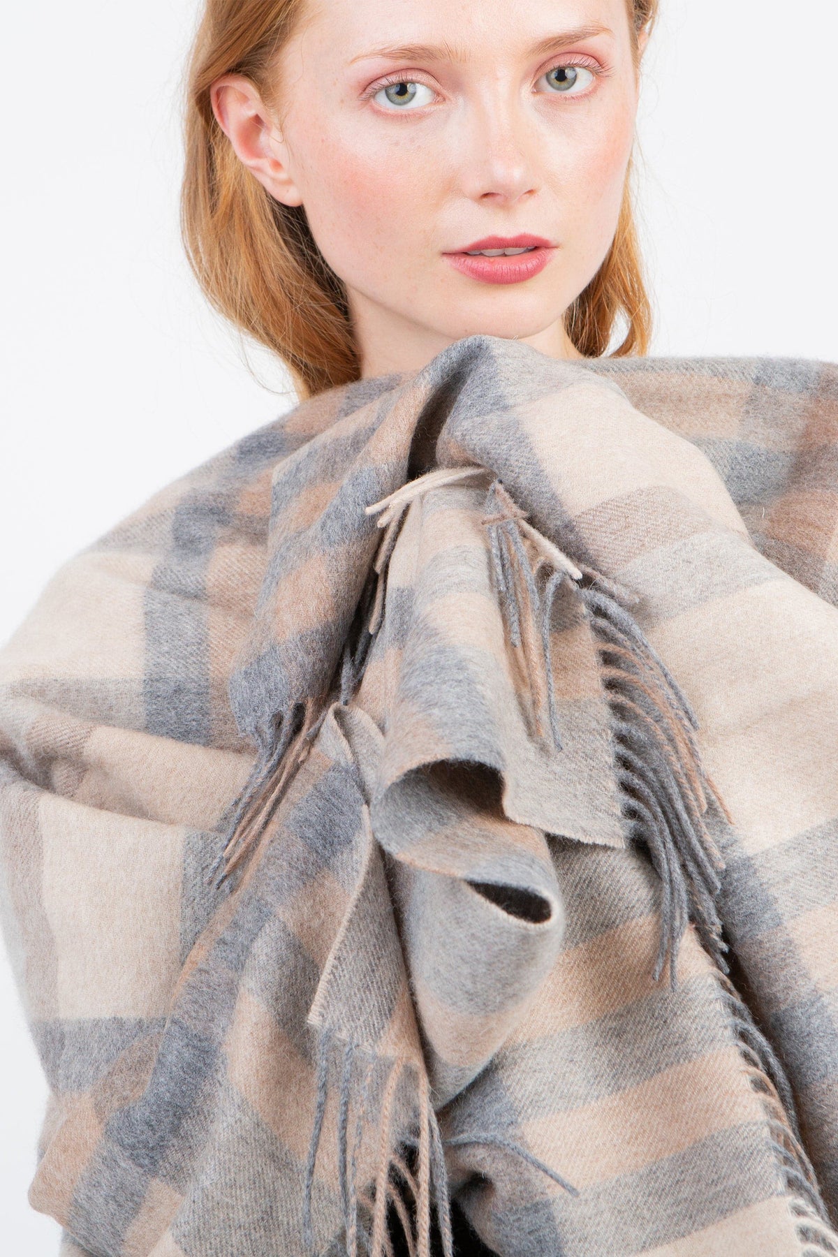 Tartan 2 Lambswool Wrap in Natural worn by model, close-up showing soft plaid texture and fringed edges in beige and grey tones