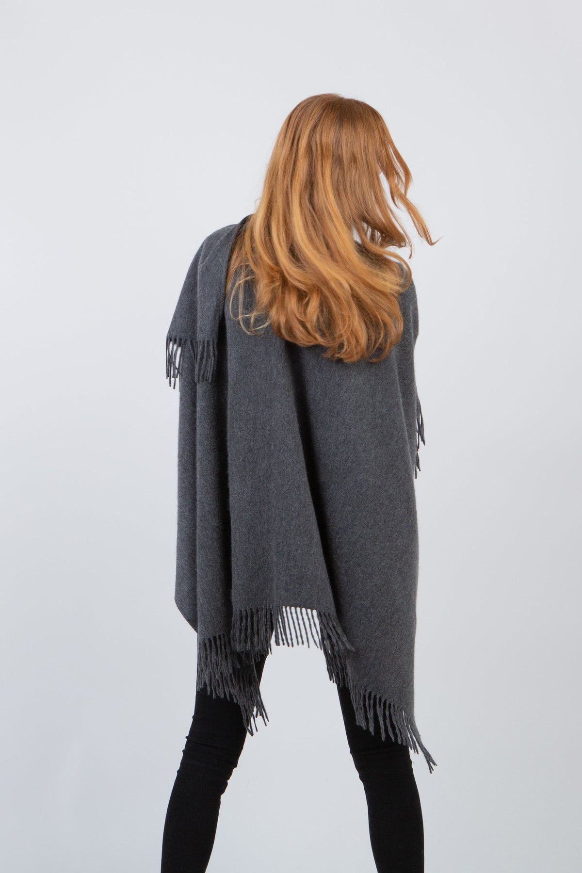 Back view of the Solid Lambswool Wrap in Steinway Grey draped over shoulders, showing fringed edges and full coverage