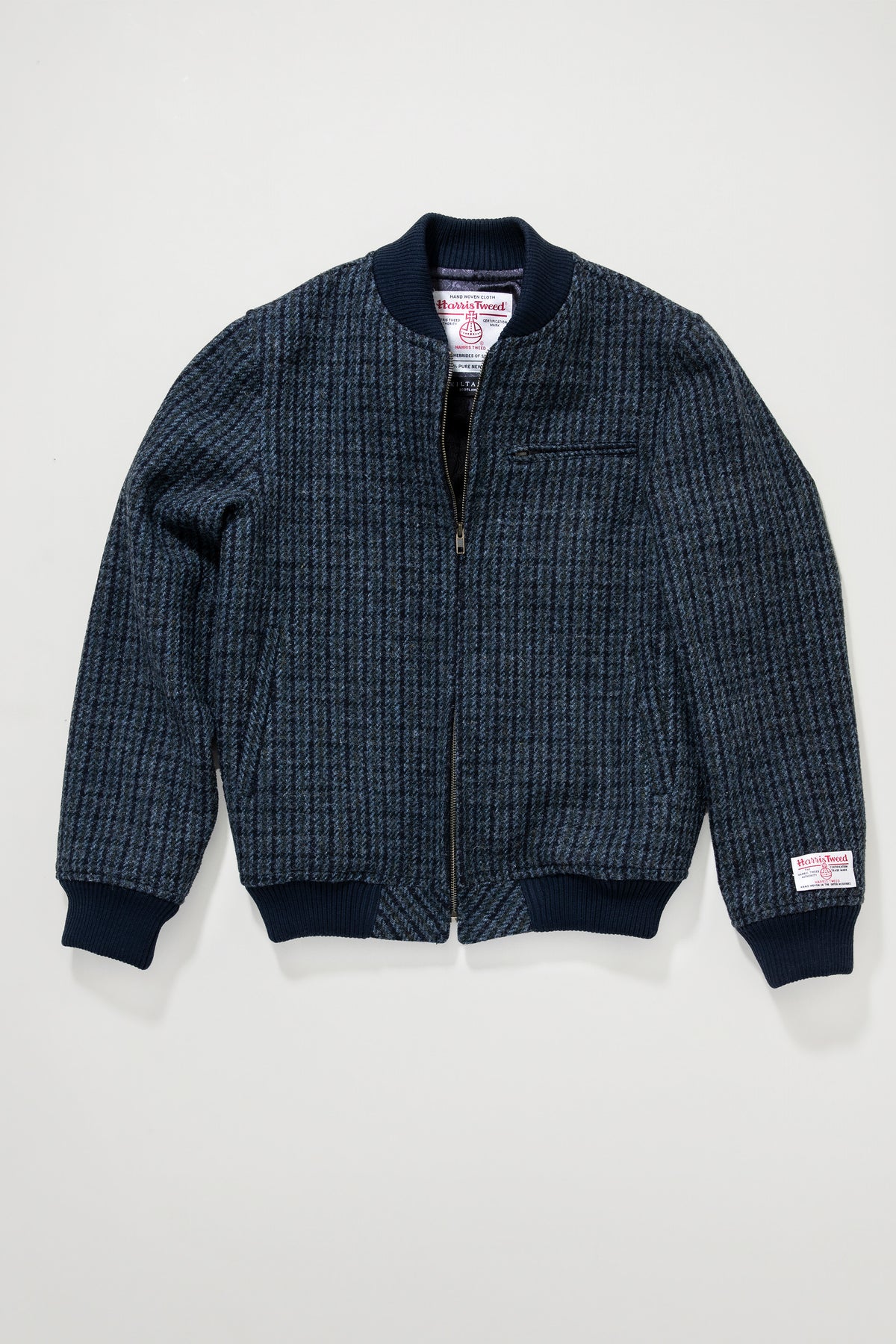 Men's Harris Tweed Bomber Jacket in blue dogstooth, front view unzipped showing interior label and ribbed cuffs