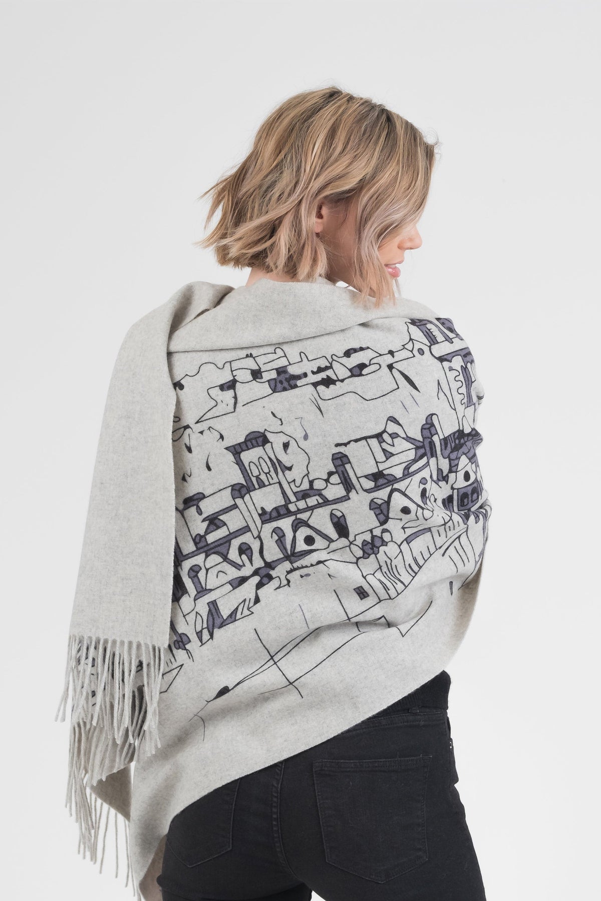 Back view of Skyline Cashmere Double Sided Stole in grey, showing black cityscape illustration and fringed edges draped over shoulders