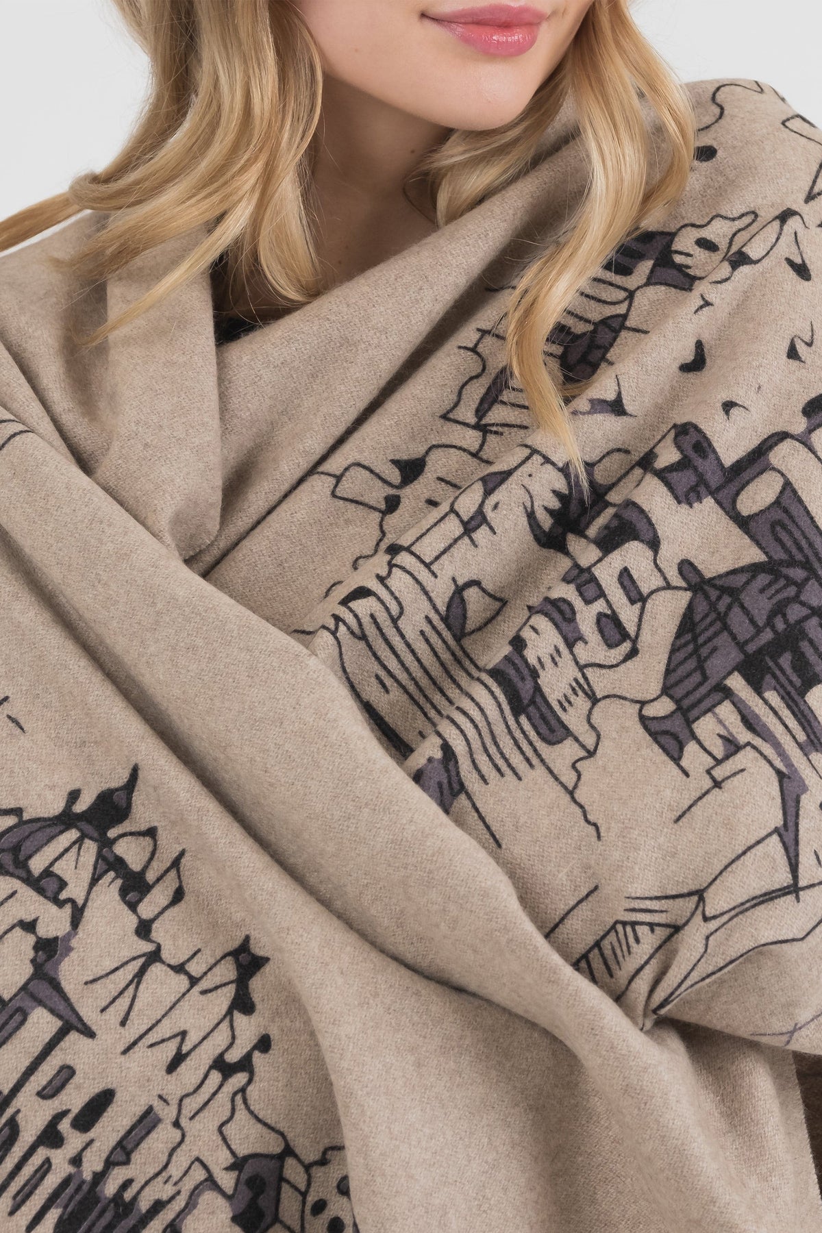 Close-up of Skyline Cashmere Double Sided Stole in beige, showing detailed black cityscape print draped around shoulders
