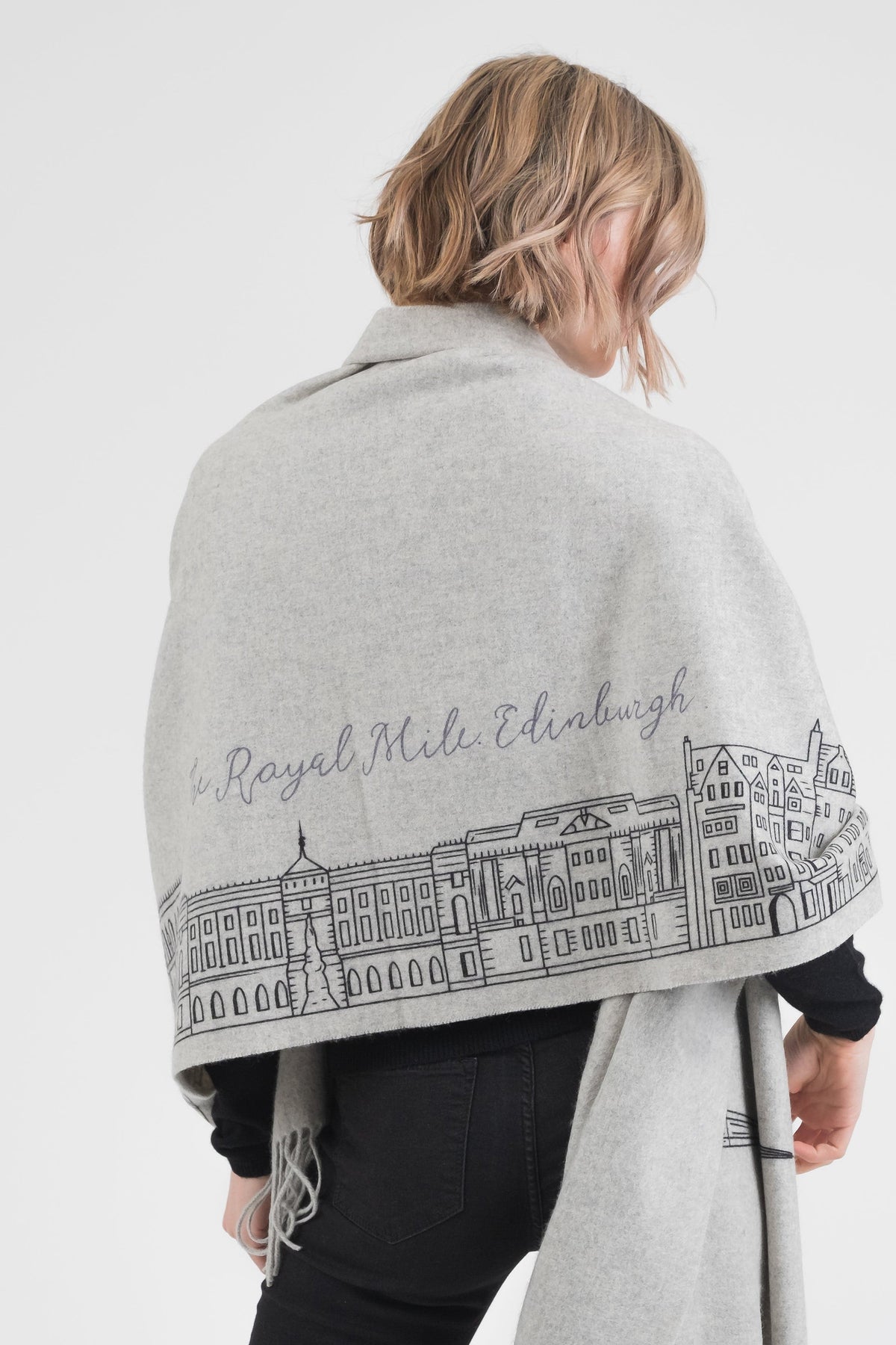 Back view of Royal Mile Cashmere Double Sided Stole in grey, showing Edinburgh Royal Mile skyline illustration draped across shoulders