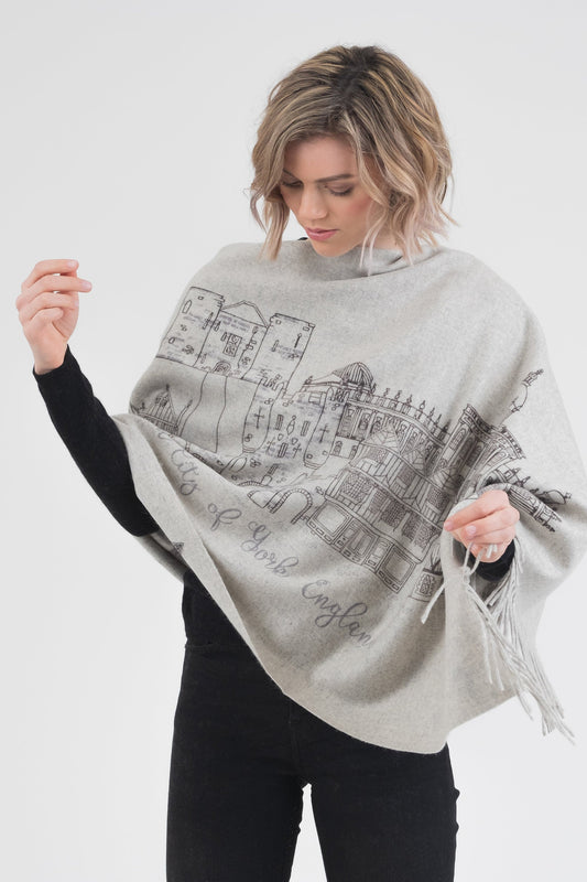 City Cashmere Double Sided Stole - York in light grey, worn as poncho showing handprinted York cityscape illustration with fringed edges