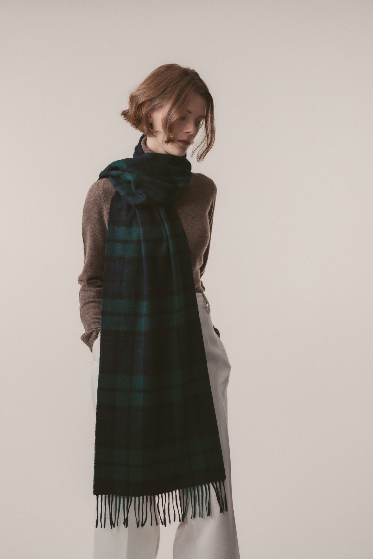Heritage Tartan Cashmere Wide Scarf in Blackwatch worn draped over the shoulder, showing full length with fringed ends