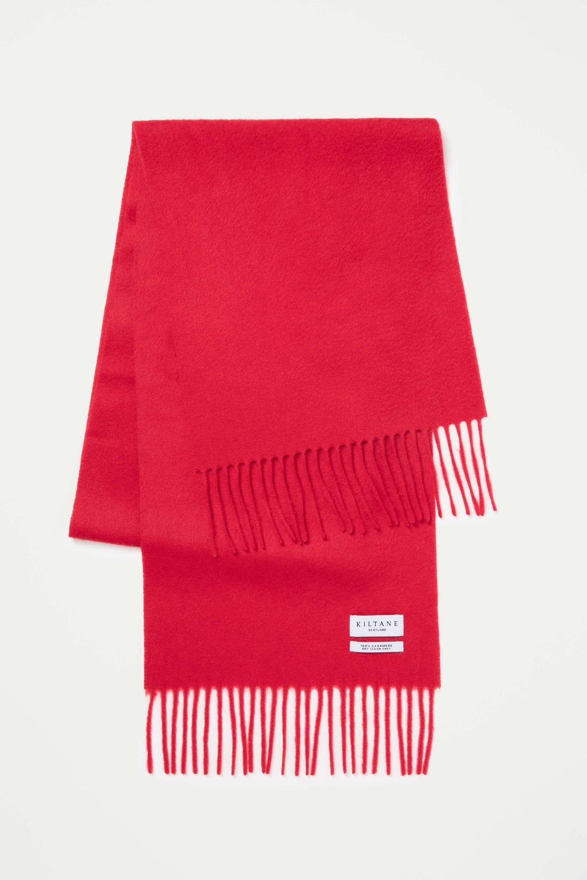 Kiltane Solid Cashmere Scarf in Red folded flat showing soft texture, fringed ends, and brand label