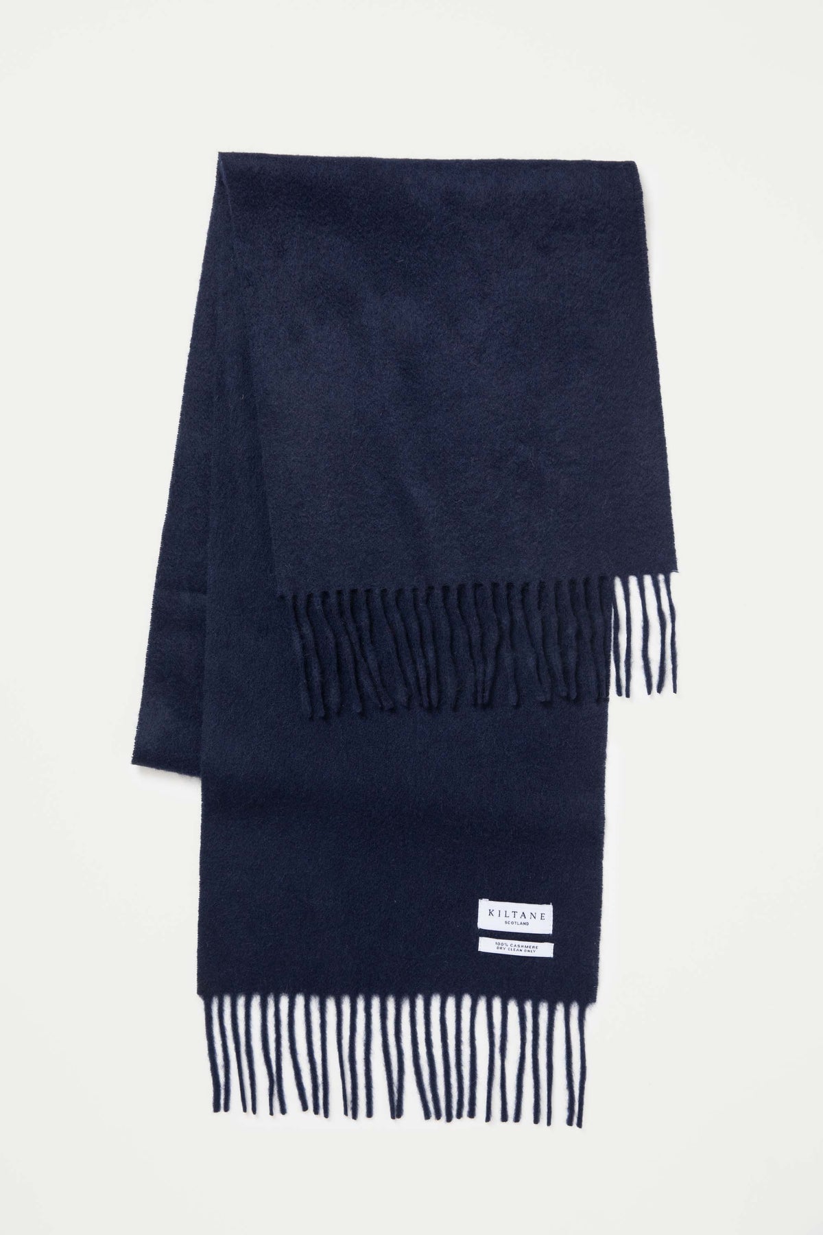 Kiltane Solid Cashmere Scarf in Dark Navy folded flat showing fringed ends and brand label