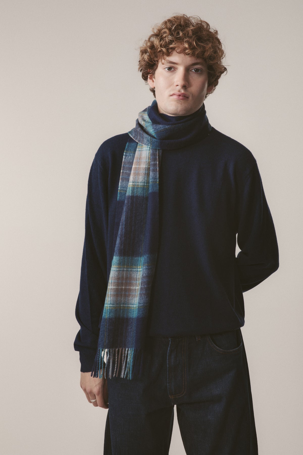 Heritage Tartan Cashmere Scarf in Holyrood blue tartan plaid with fringed ends, styled draped over a navy sweater